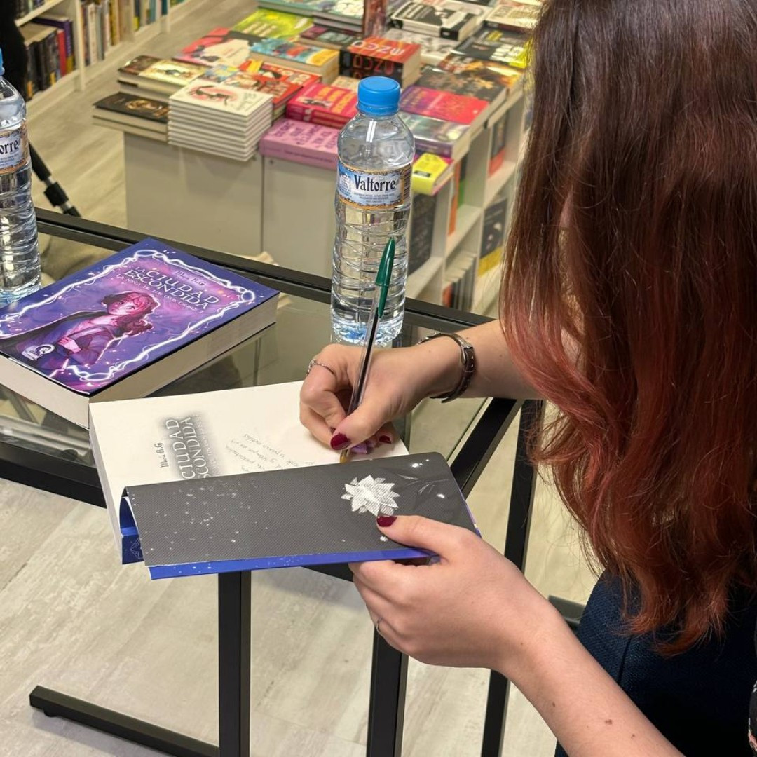 María firmando ejemplares de La ciudad escondida.