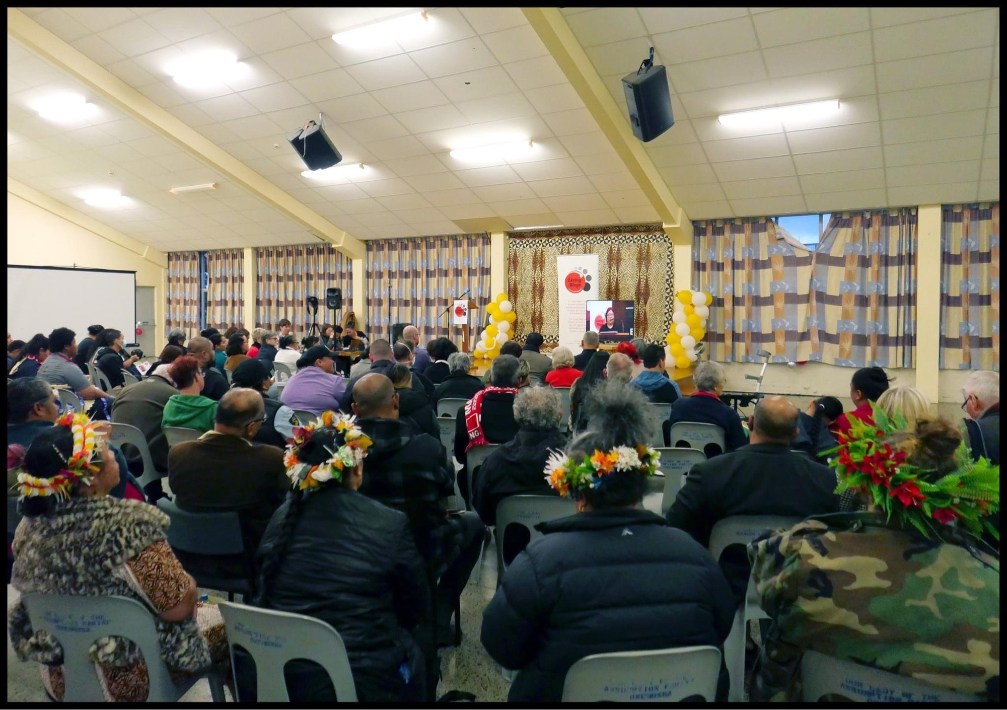 Photograph of the attendees of the Living Wage Forum in Christchurch. They’re facing a screen listening to speakers from Auckland and Wellington. Three forums were linked because the Living Wage for public service workers includes workers from all over Aotearoa not just Wellington.