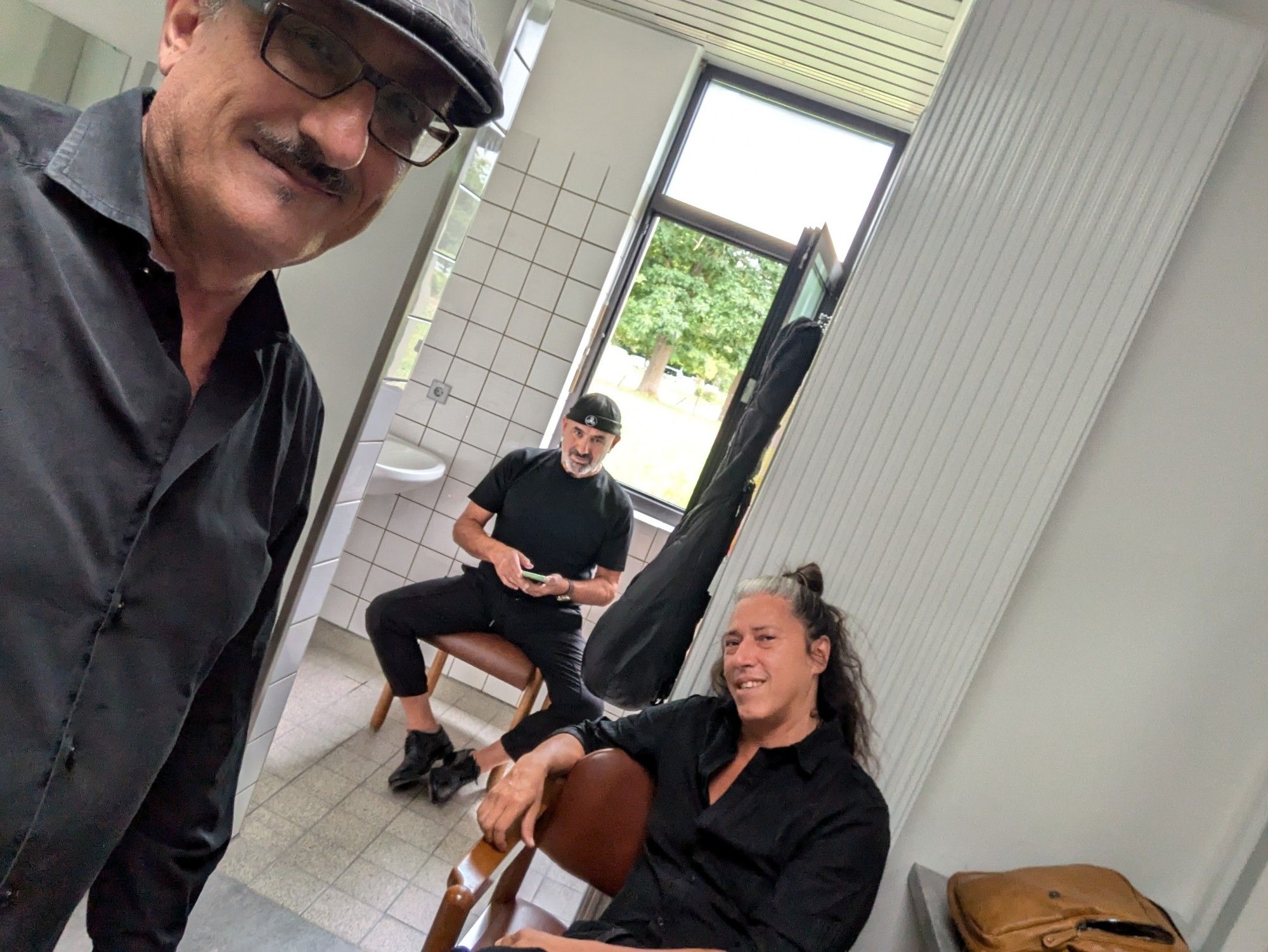 Three musicians sitting in the green room before the show