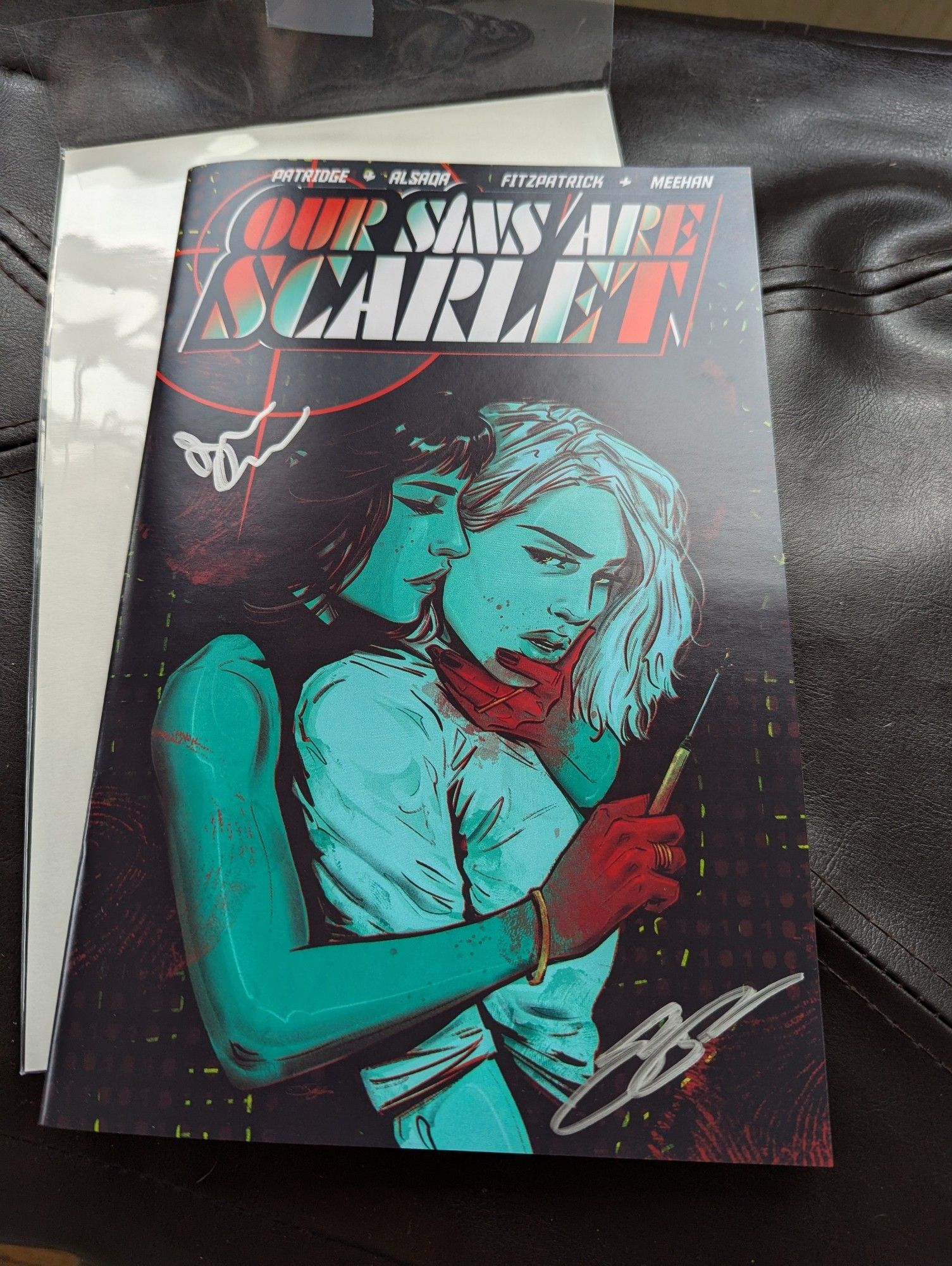 a picture of the cover of the comic our sins are scarlet, signed by jordan alsaqa and skylar partridge