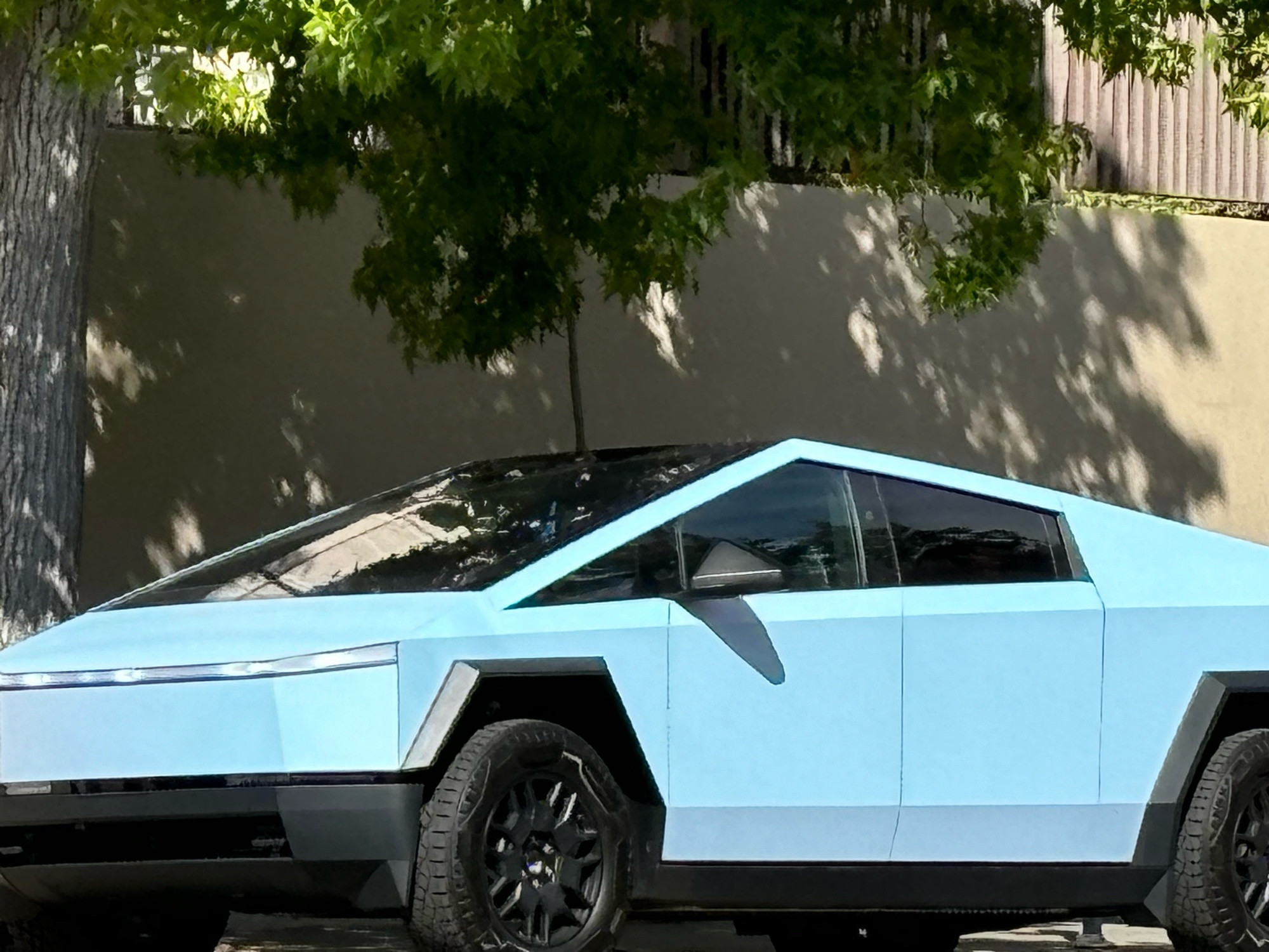 Partial view of a pastel blue cybertruck on a street