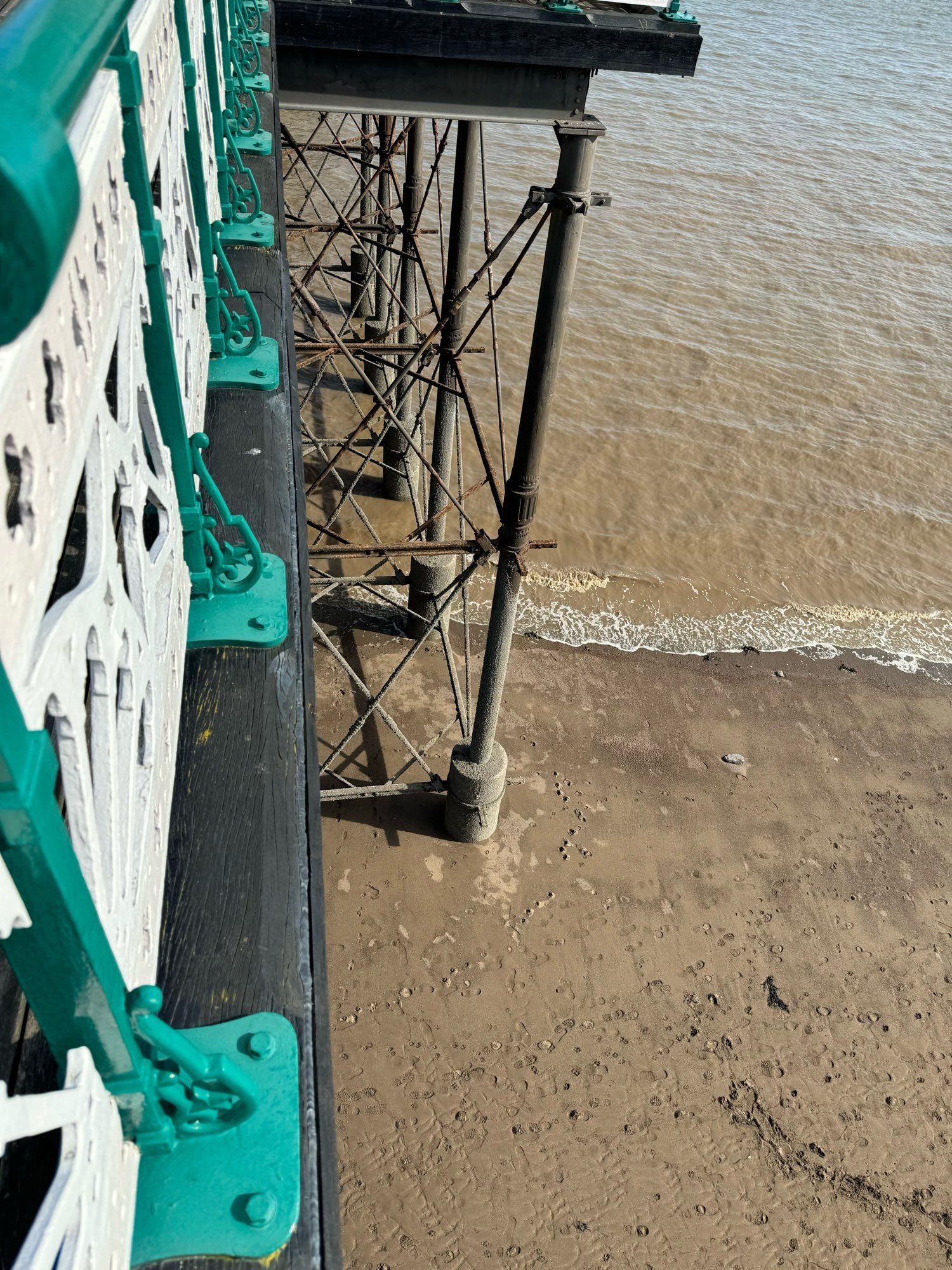 Aqua & white iron fencing on wooden pier, to centre, iron piers