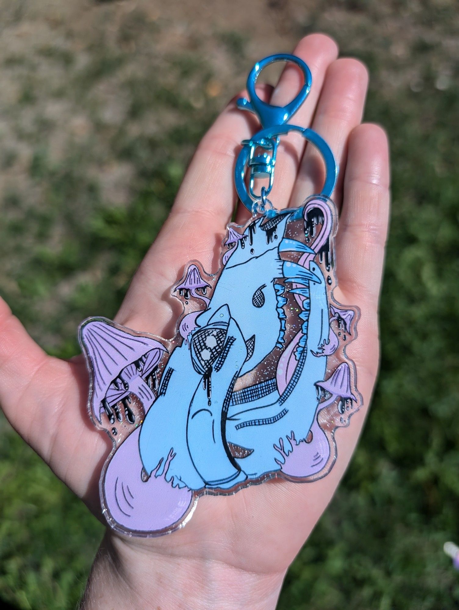 Acrylic keychain featuring a blue opossum skull with purple Inky Cap mushrooms.