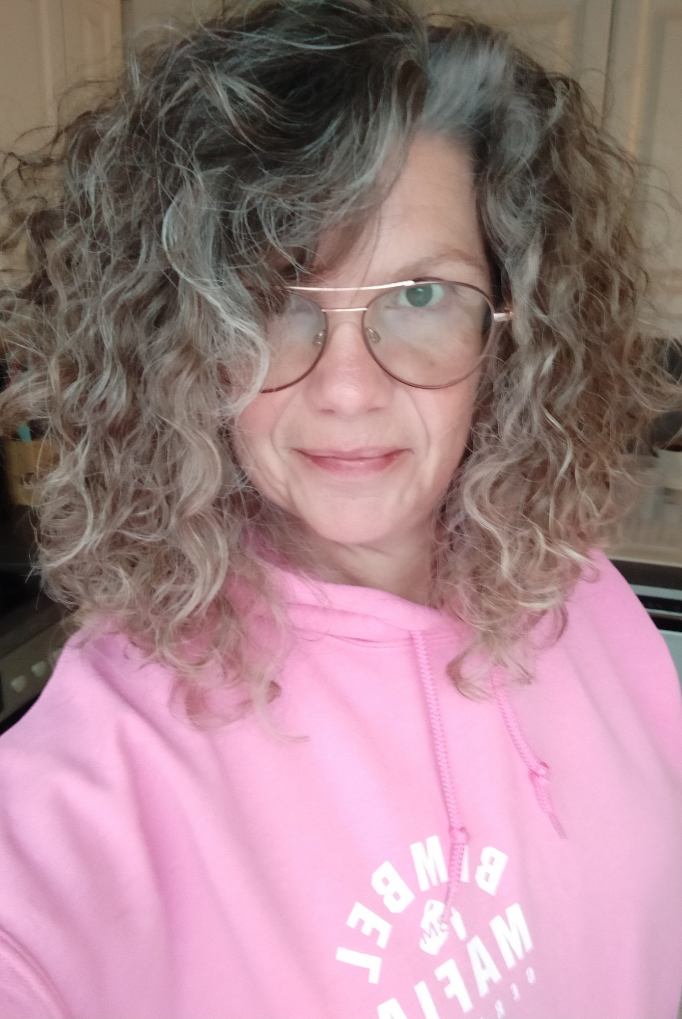 Selfie in Farbe, mit Brille, Lächeln und gewohnten Wuschelhaaren, mit Hoodie in rosa, mit weißer Aufschrift "Bembel-Mafia 