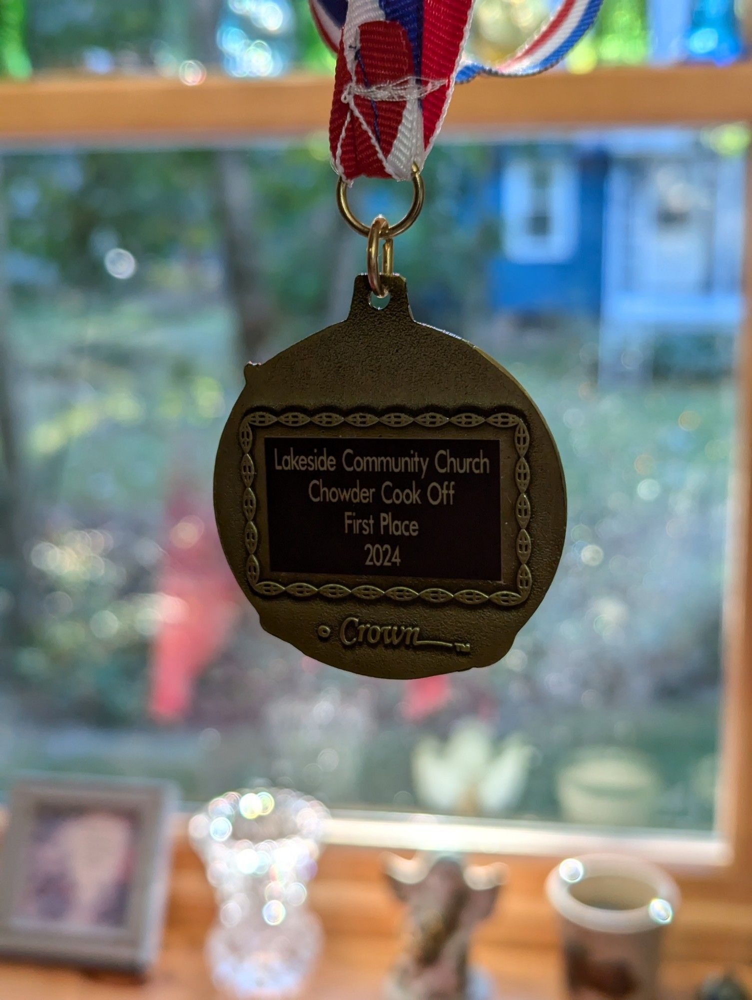 A winners medal reading "lakeside community Church chowder cook off first place 2024"