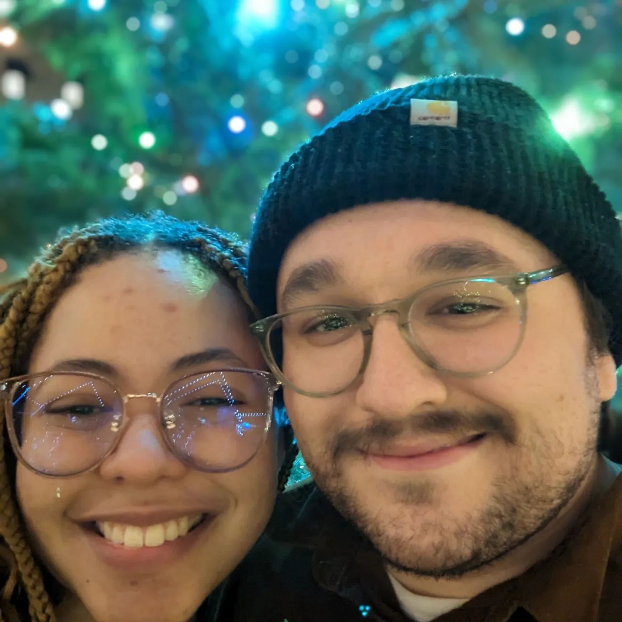 My girlfriend and I standing in front of a very big Christmas tree