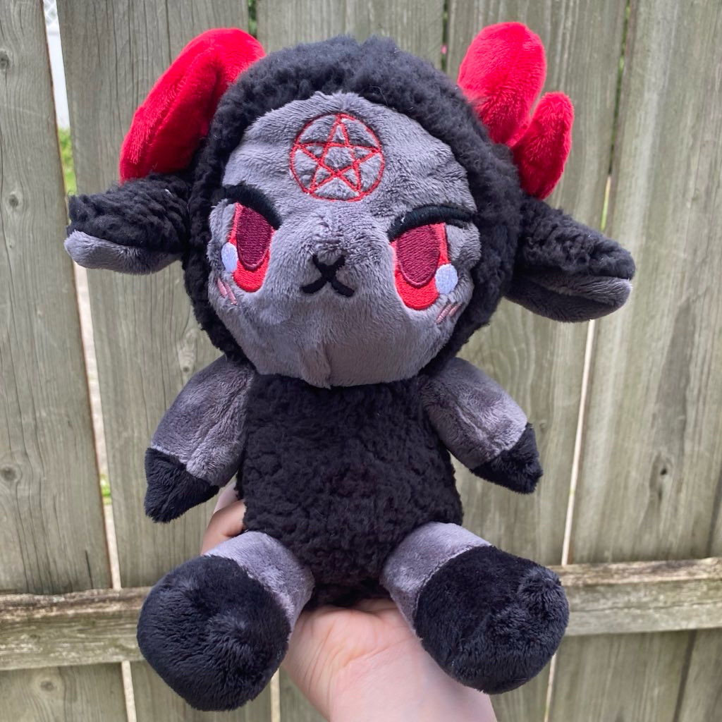 A black, gray, and red sheep demon plushie