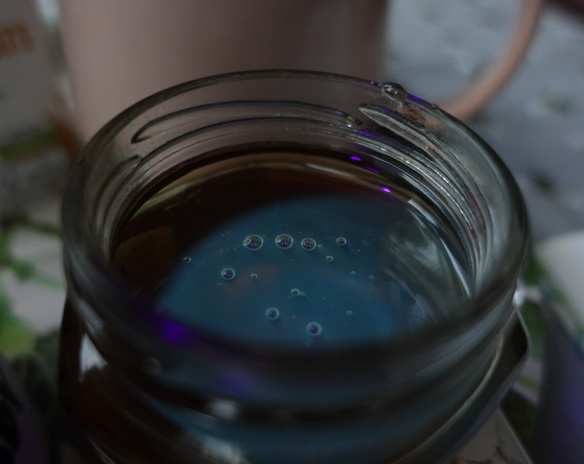 A jar of honey under the UV light. The honey absorbs the UV light and emits in the blue