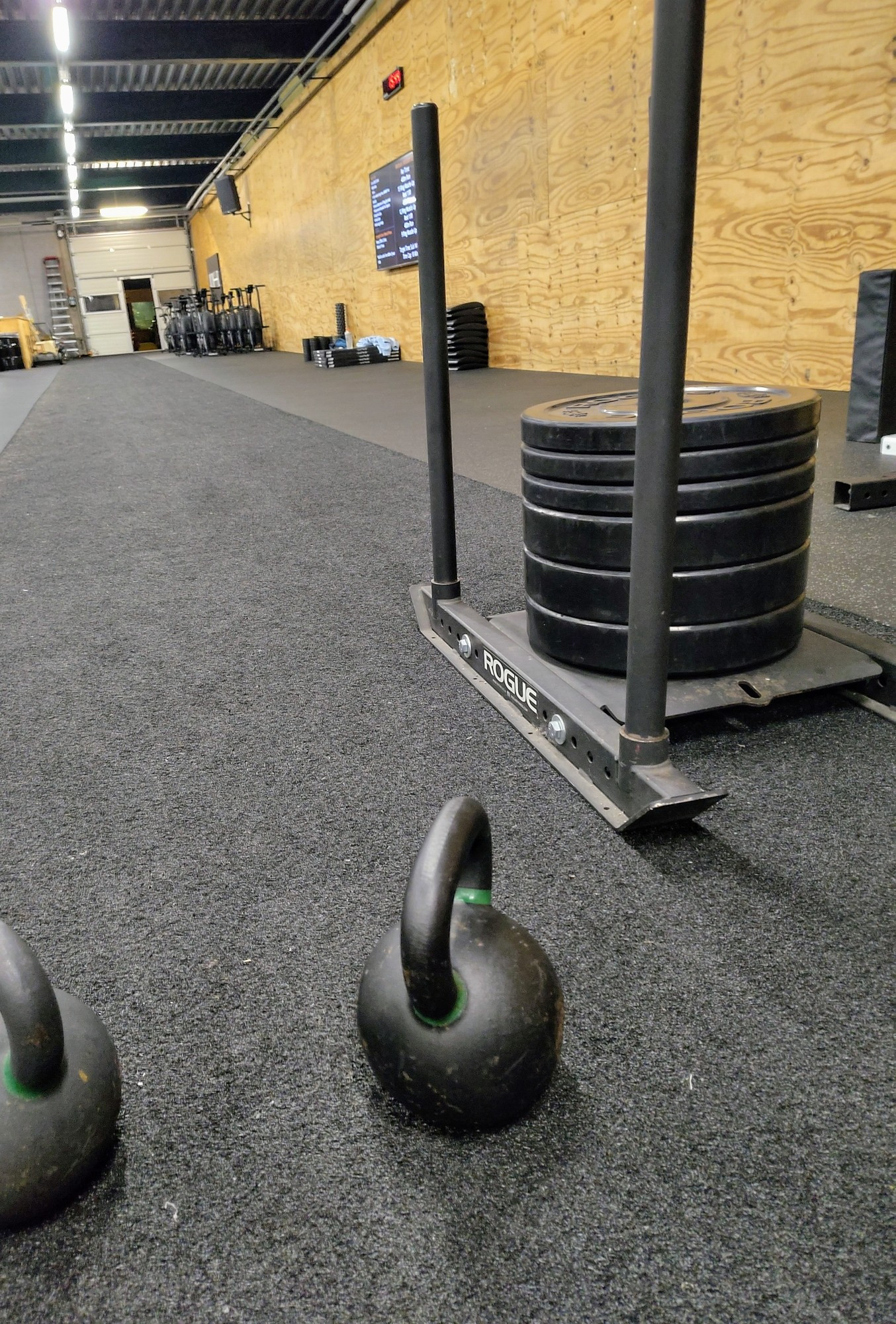 In de sportschool: 2 kettlebells van 24kg en een push sled van 136kg op een strook kunstgras van 25 meter lang.