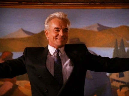 Ray Wise with White hair in a suit smiling