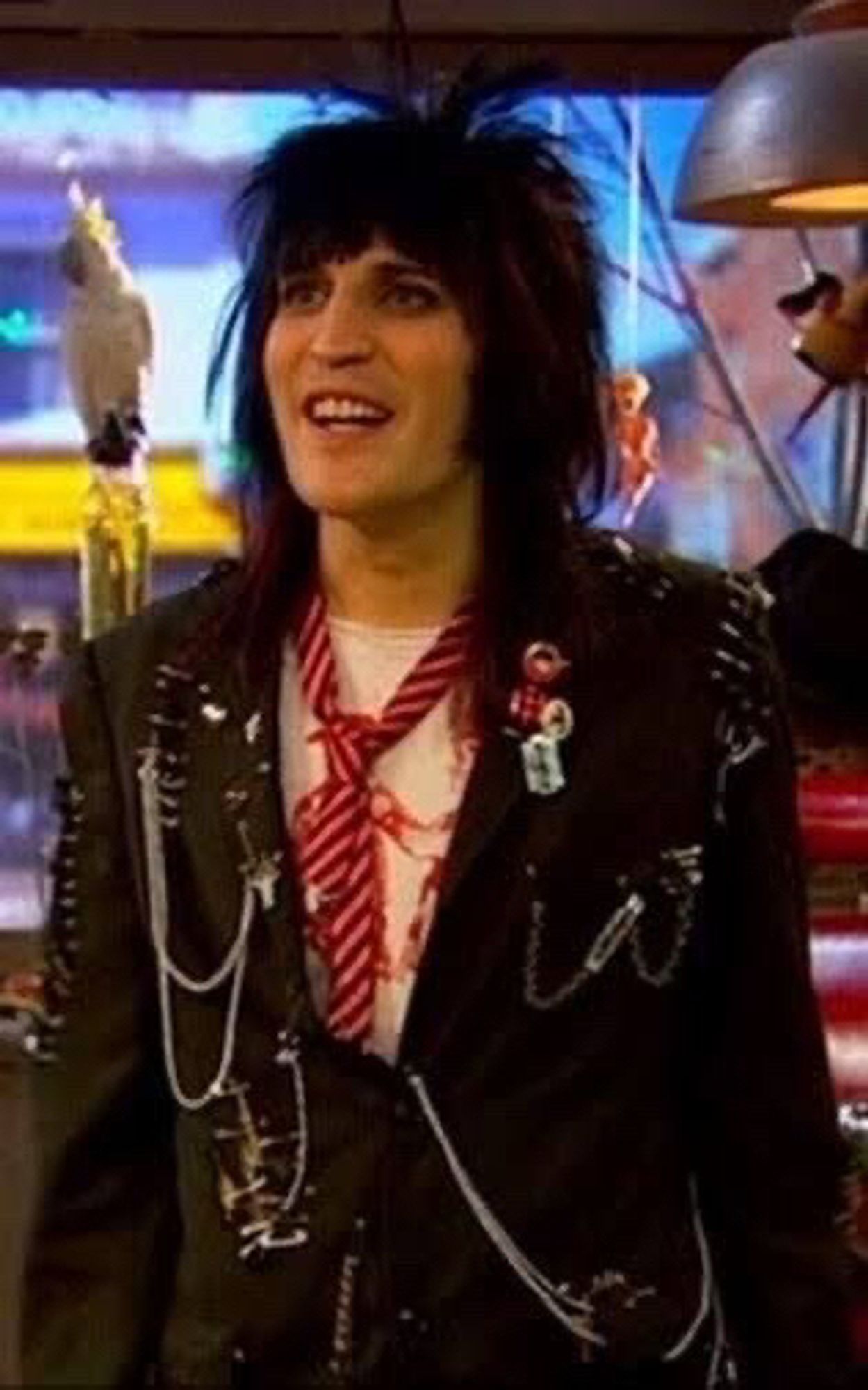 Noel Fielding as Vince Noir in the episode where he’s a punk

white br*tish man presenting very androgynously with hair like Joan Jett & heavy black eyeliner, wearing a suit jacket held together with safety pins