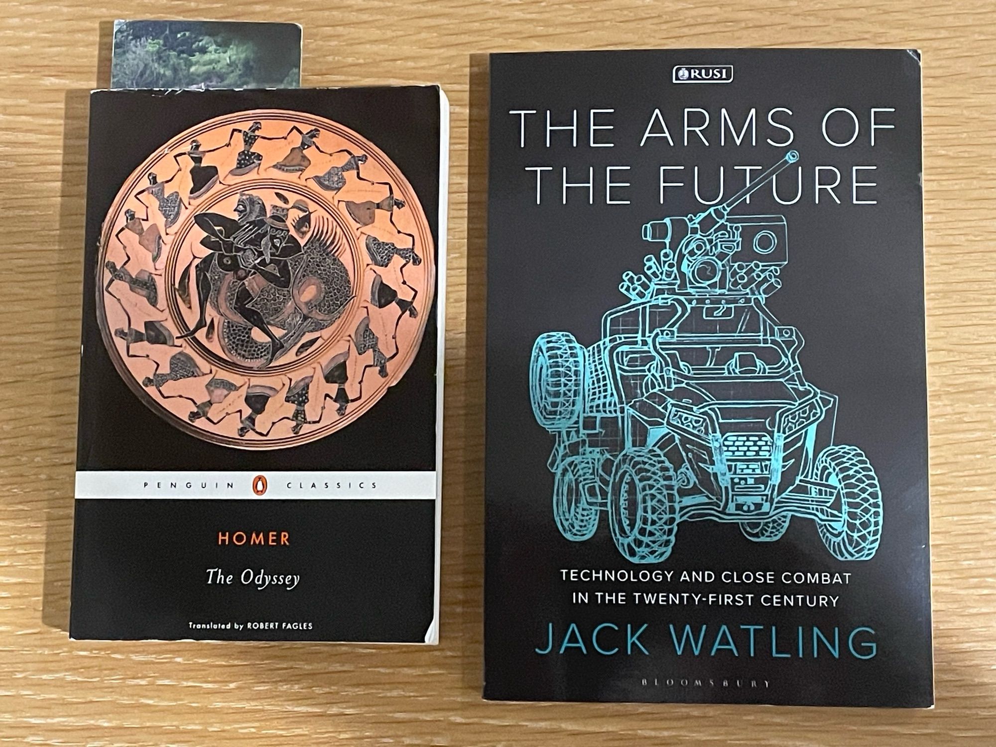 Paperback copies of two books “The Odyssey” by Homer and “The Arms of the Future” by Jack Watling