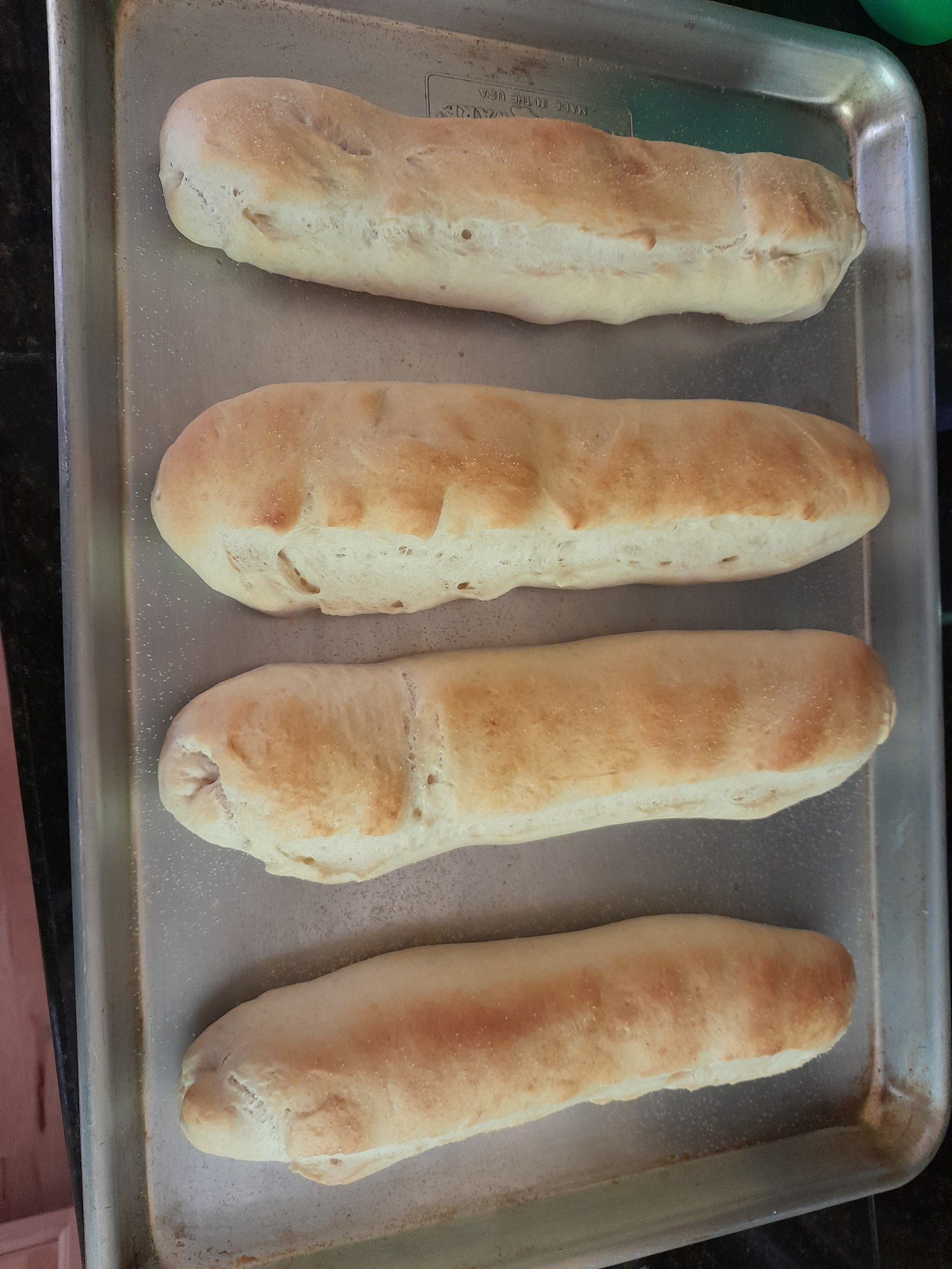 Four baked hoagie rolls