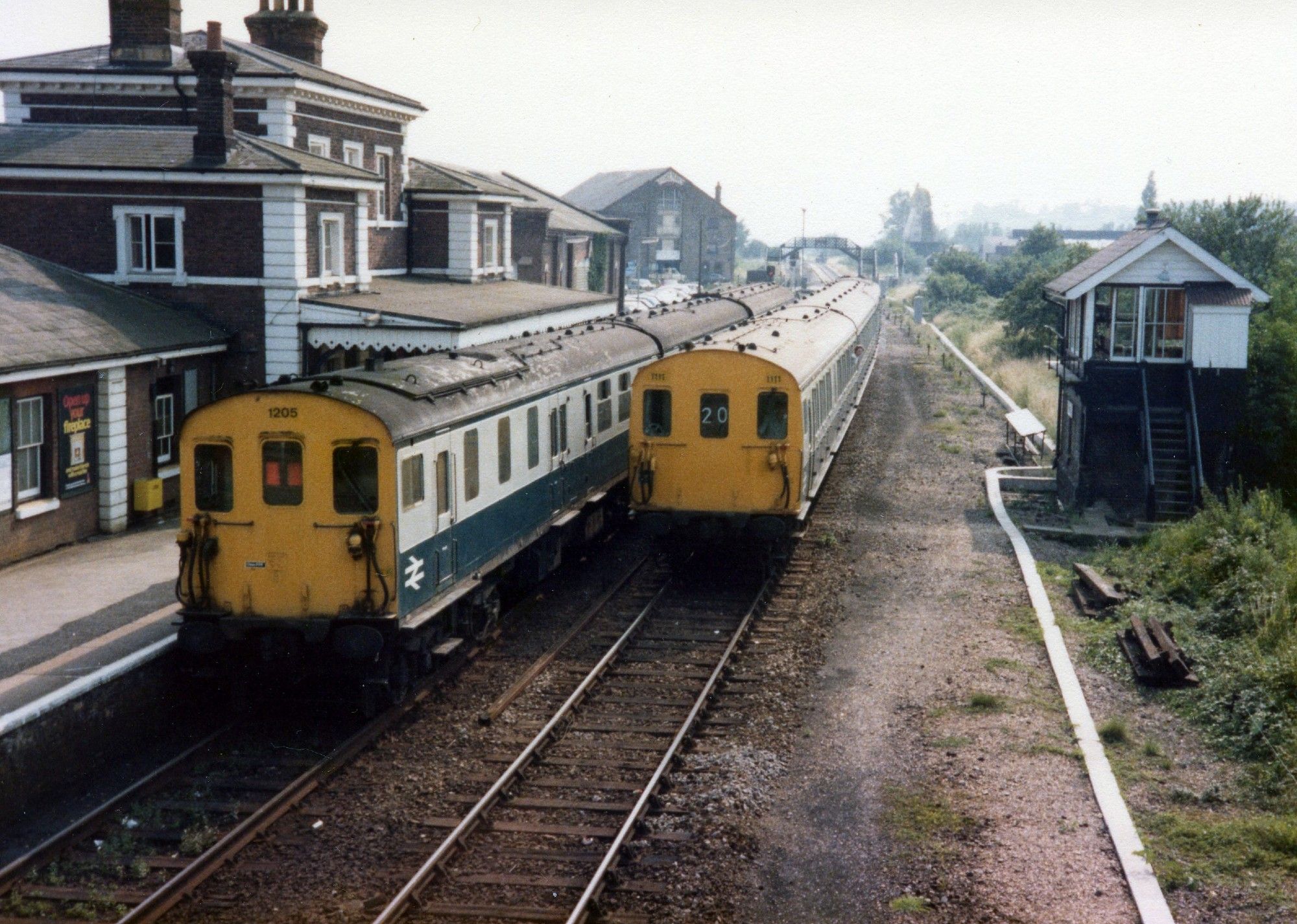 Rye Station, 1980. Refurbished 3H unit 1111 from Hastings, with headcode 20, passes 3R 'Tadpole' unit 1205 at the platform, showing the 2 red blinds in the headcode window. Both in BR blue/grey livery.