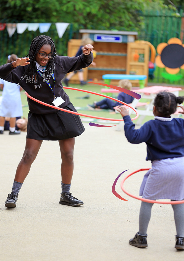 Two girls with braids hoola hooping in a playground