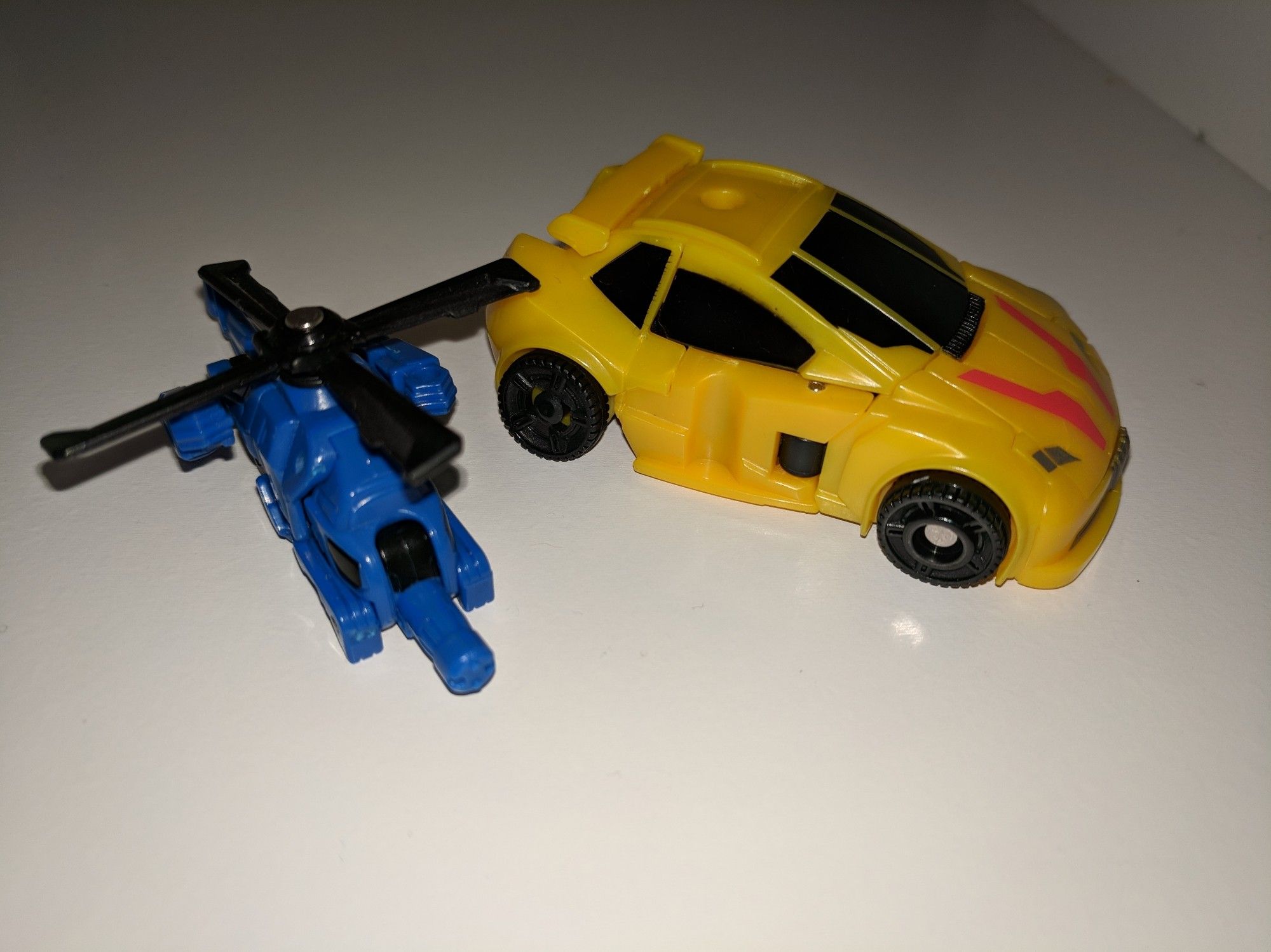 A little yellow "cybertronian" car with an even smaller little blue helicopter.