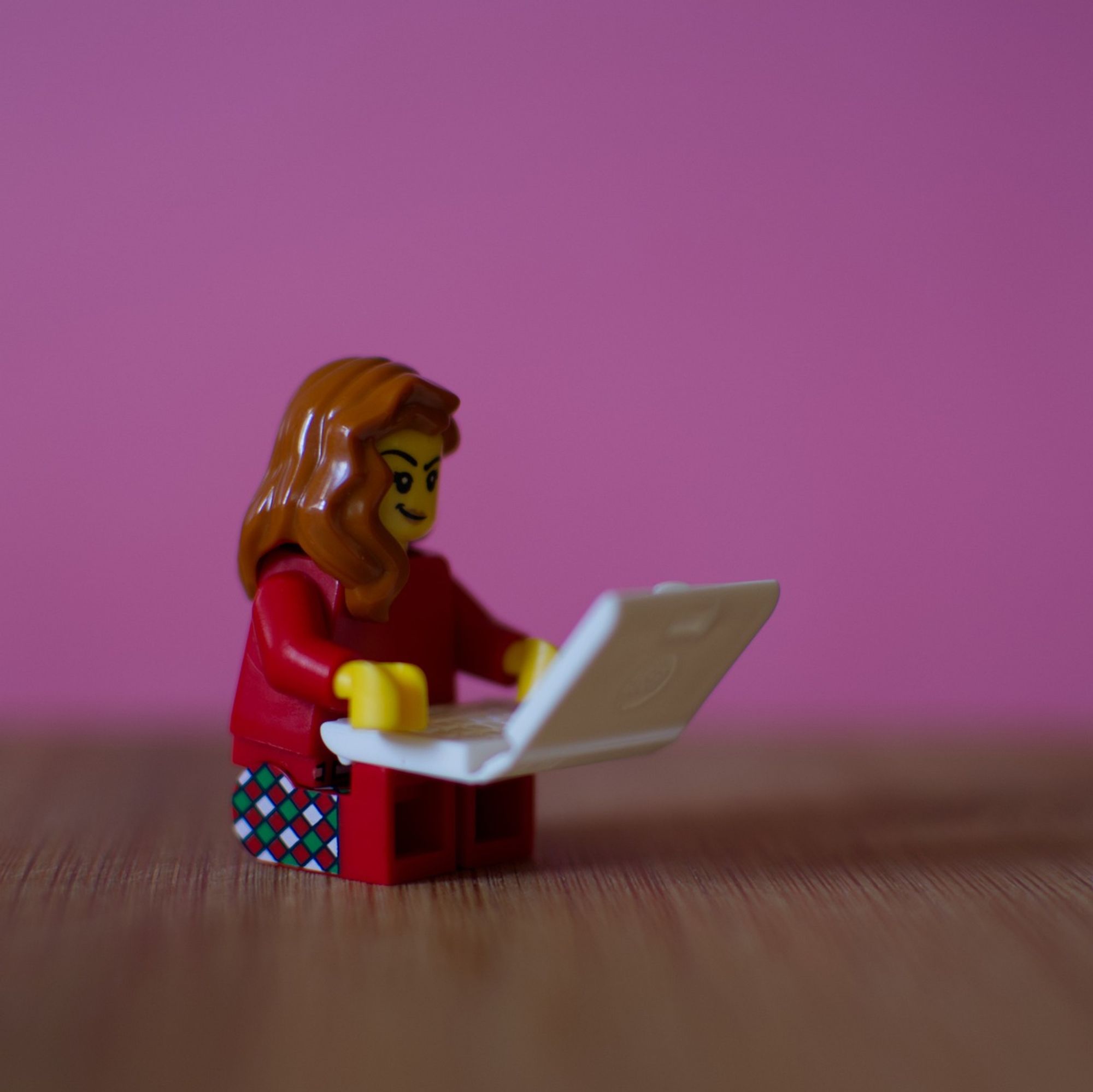 lego mini figure of a girl holding a laptop