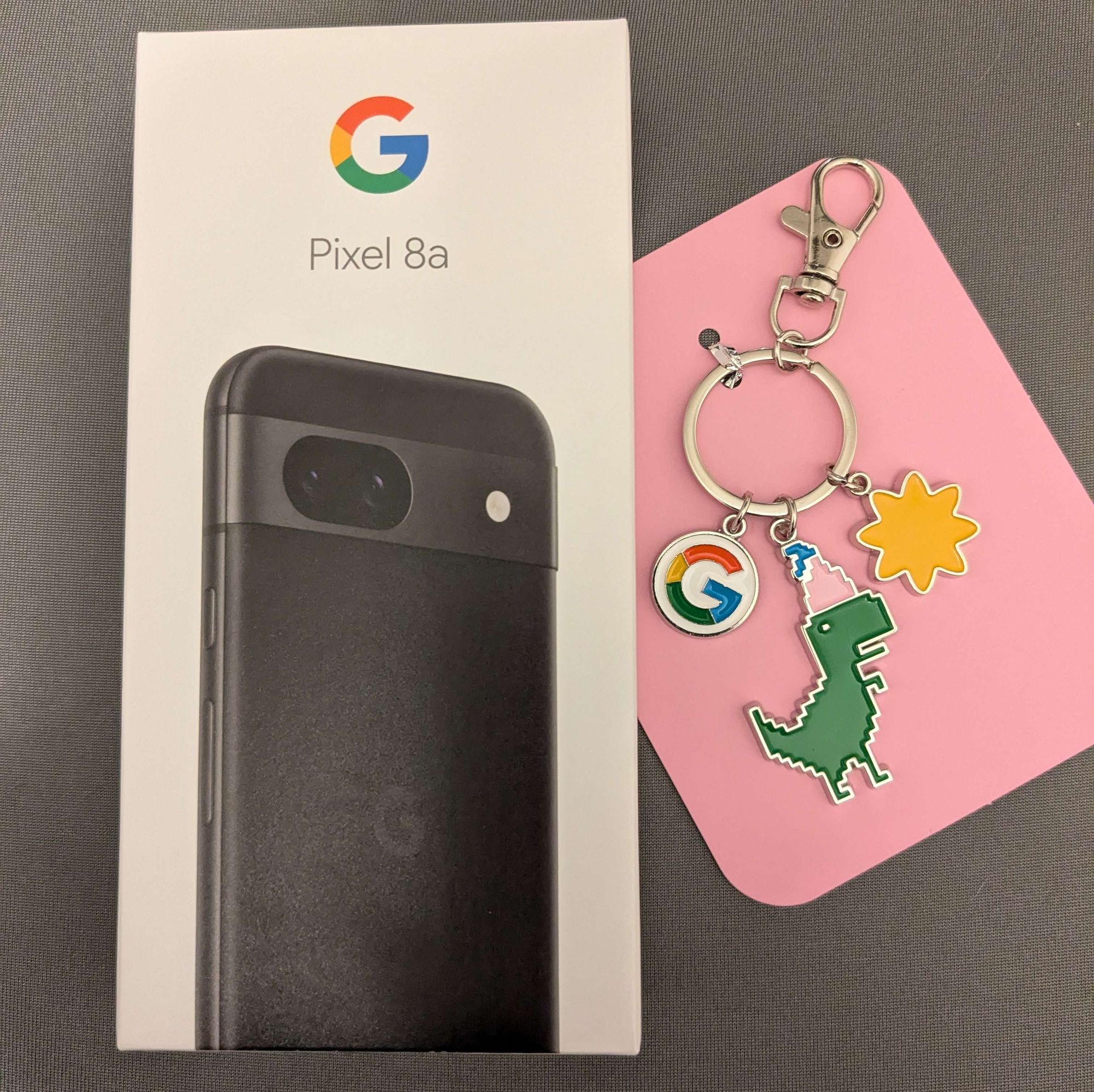 Google Pixel 8a und ein Google Birthday Schlüsselanhänger