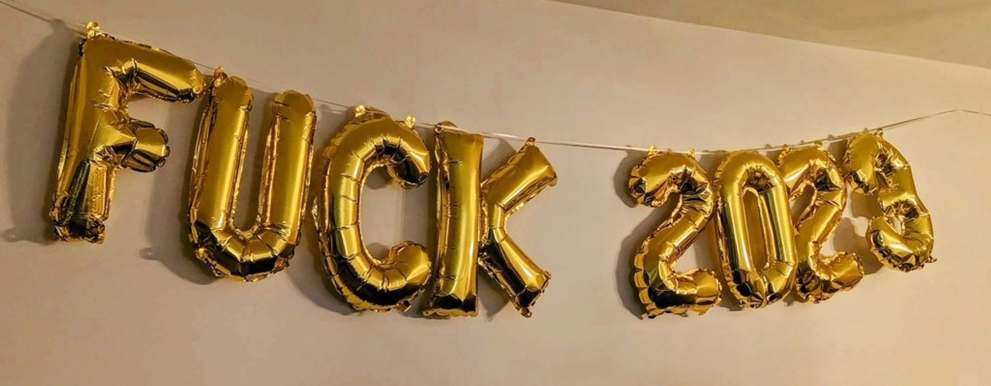 Gold balloons in the shape of "Fuck 2023"