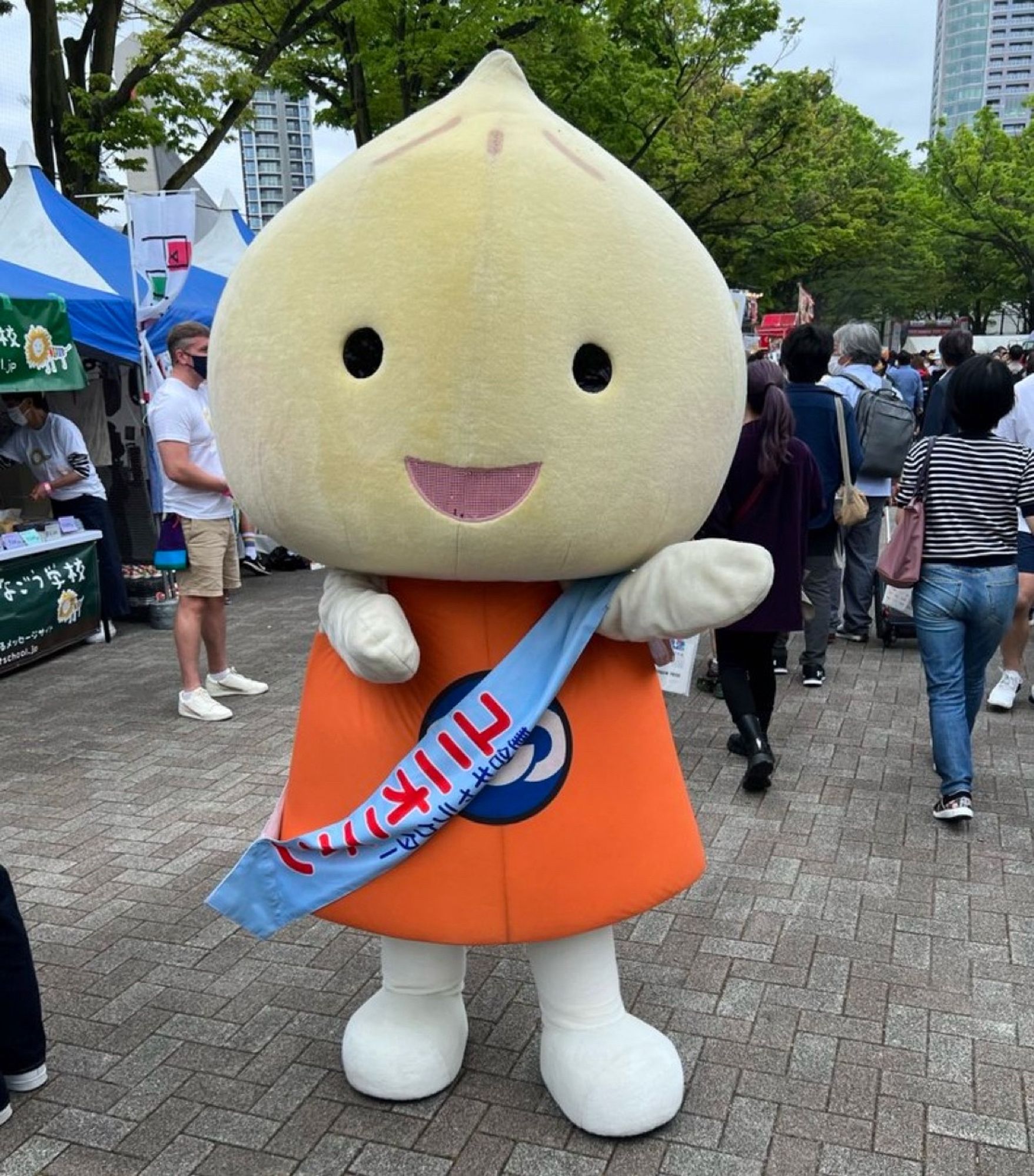 Unionion - orange dress, white boots, big smiling onion for a head (wearing a pale blue sash with red writing on it)