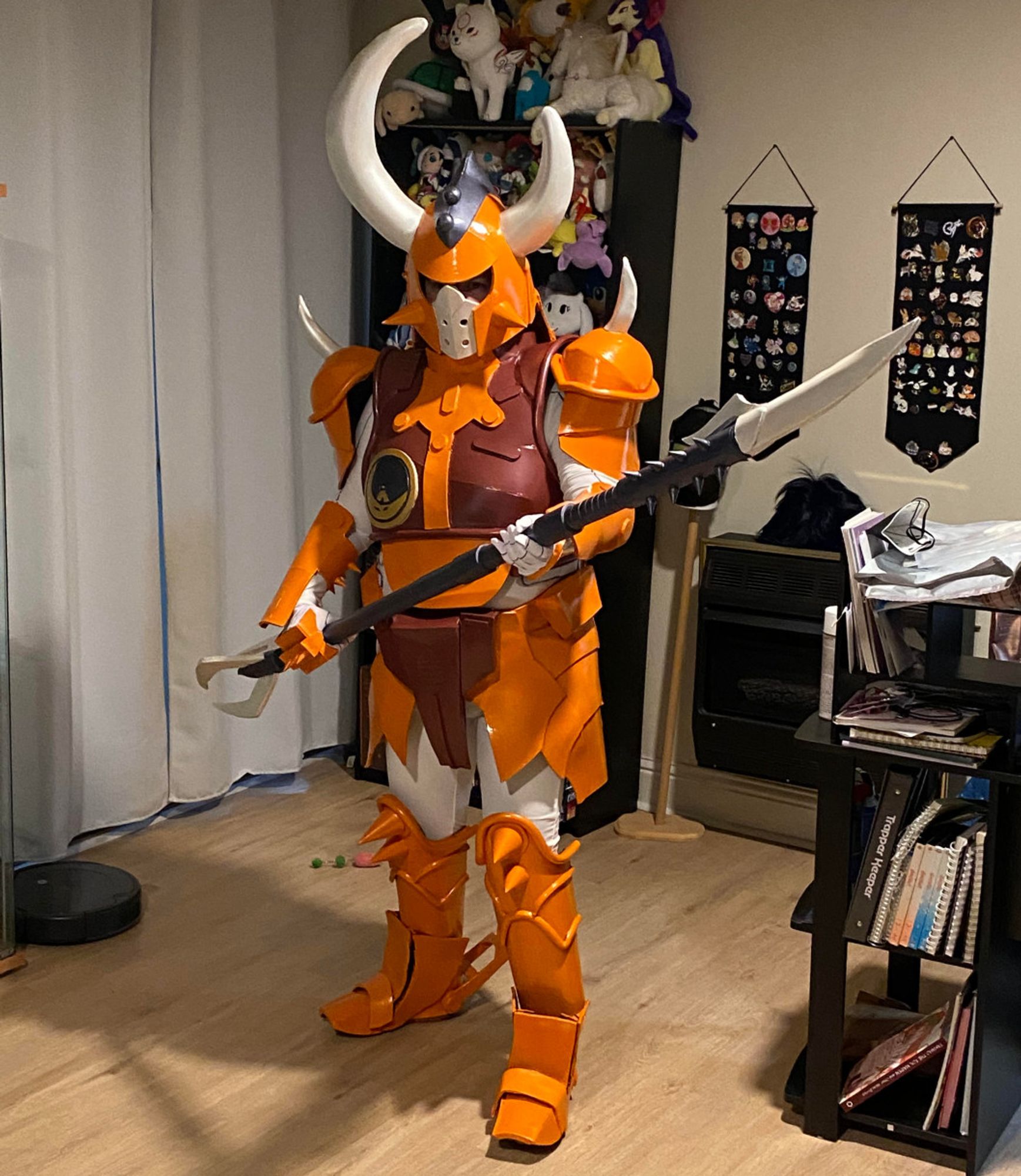 A person wearing bright orange, white, and maroon armor and holding a spiky glaive.