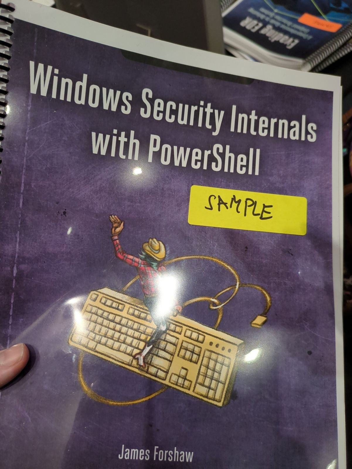 A sample printing of my next book, windows security internals with powershell. Cover is a cowboy riding a keyboard.