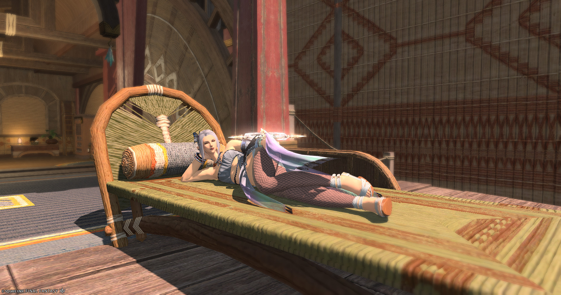 A screencap from final fantasy xiv. A female elezen lies in the sun in the Tuliyollal inn room. She is reclined on a wicker woven patio lounger in the sun, resting her head with her hand propped up on her elbow with her eyes closed. She's dressed in pastels and wearing sandals.