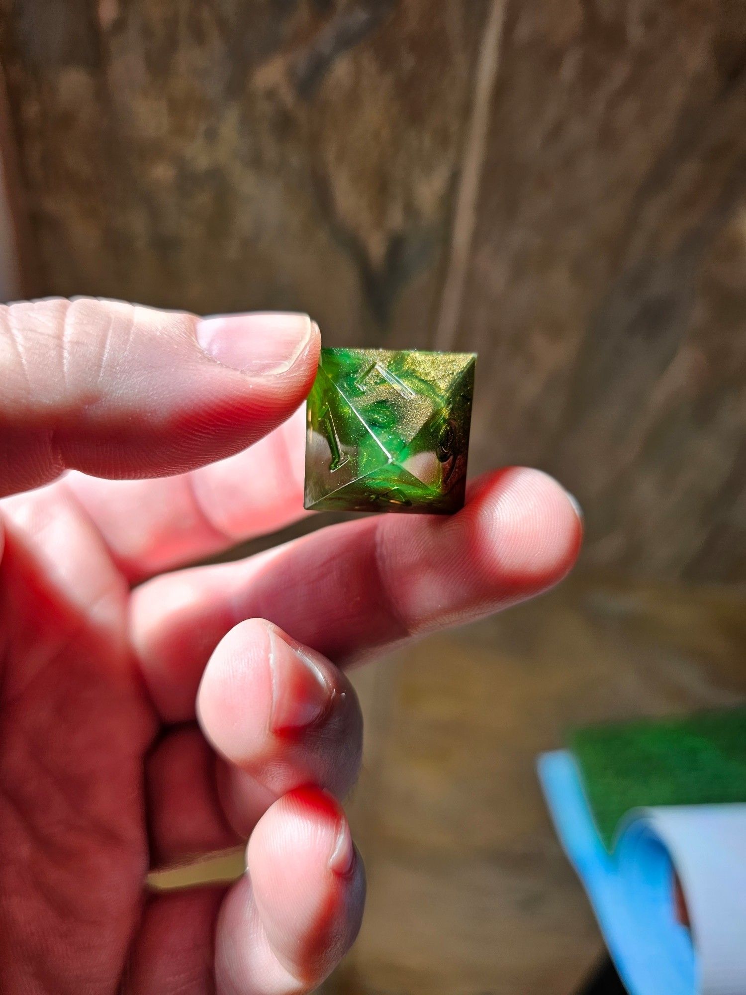 A hand holding a d10 polyhedral die.