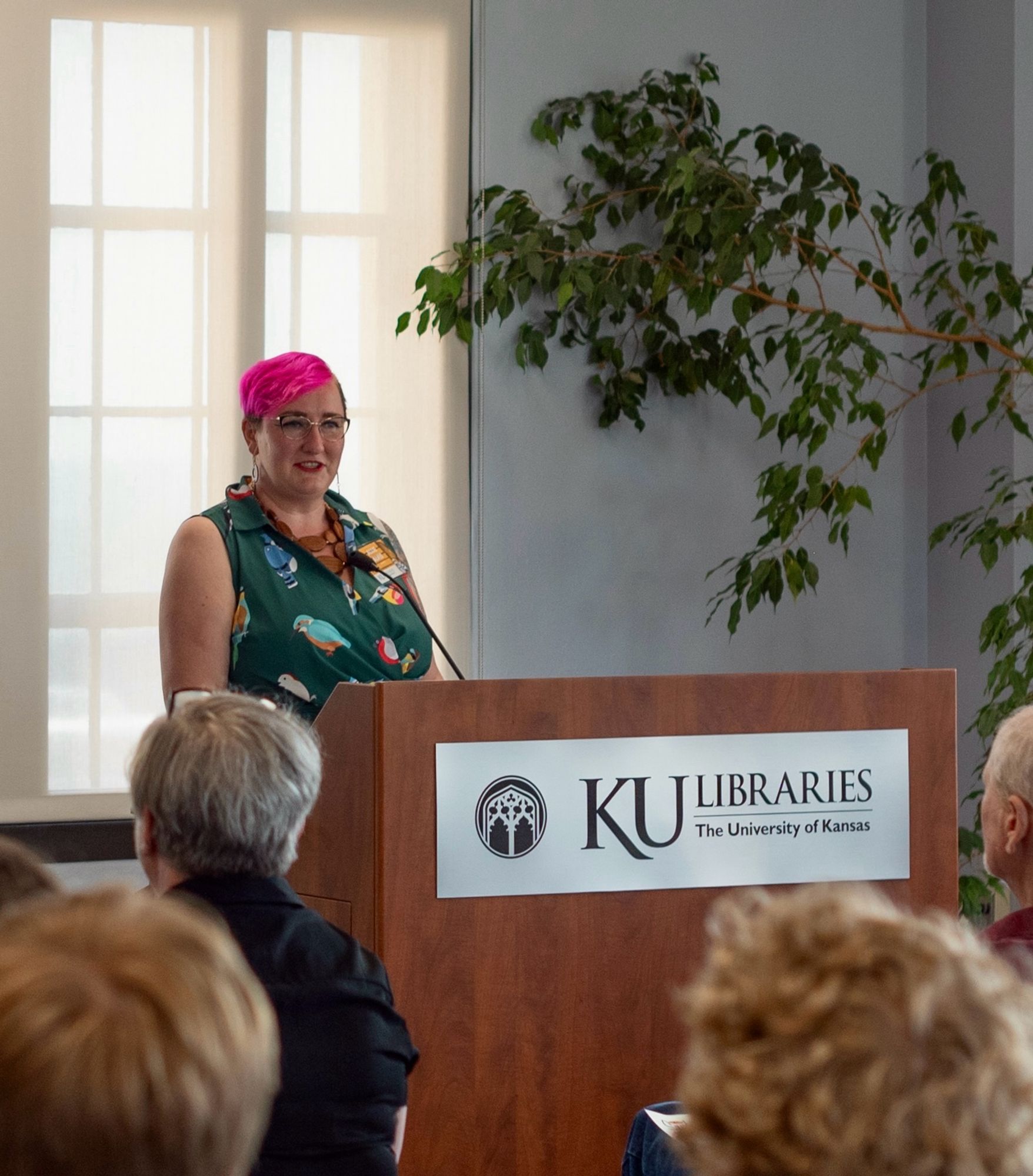 Allie speaking behind a podium at the University of Kansas