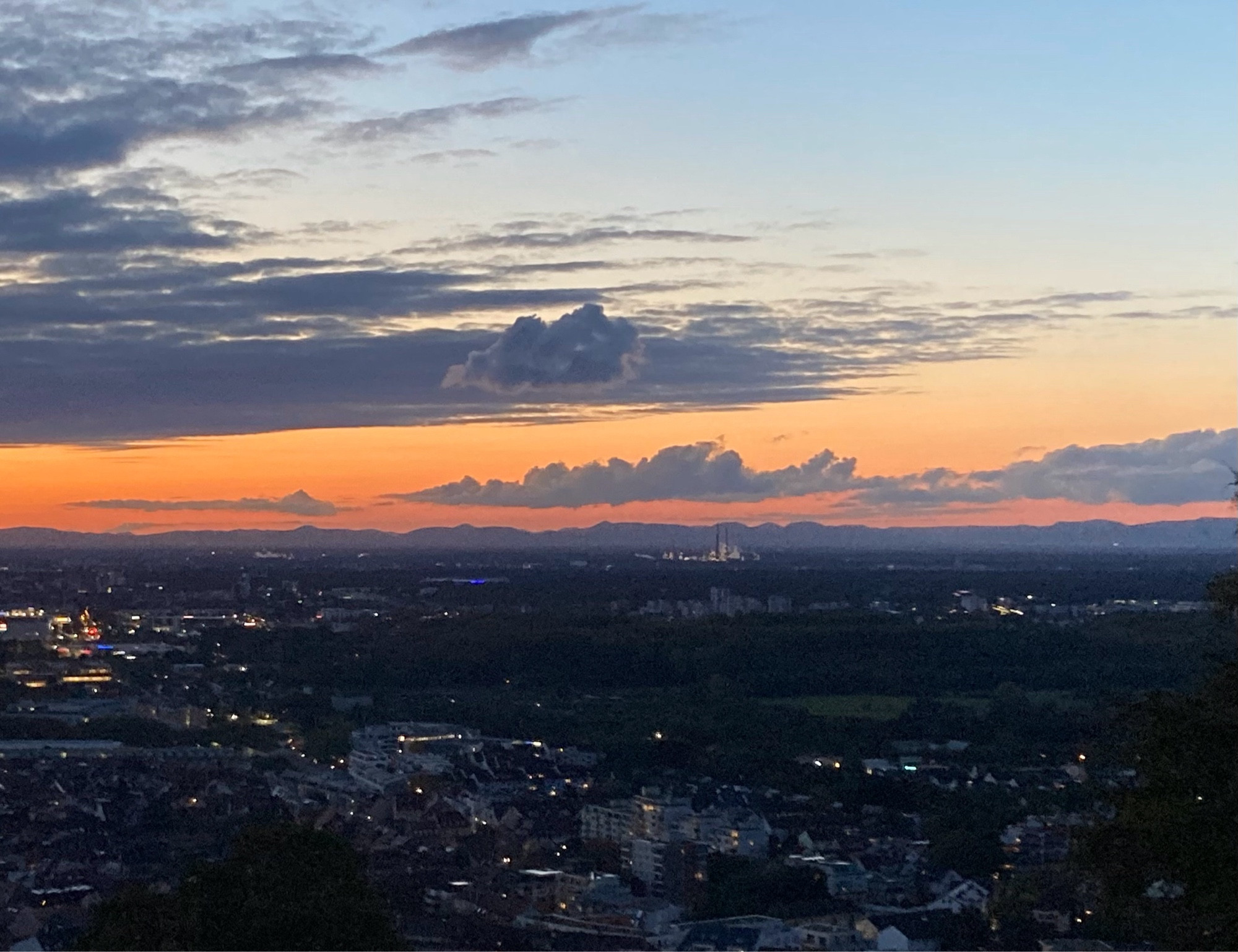 Abendhimmel mit Wolken und Abendrot über einer Stadt.