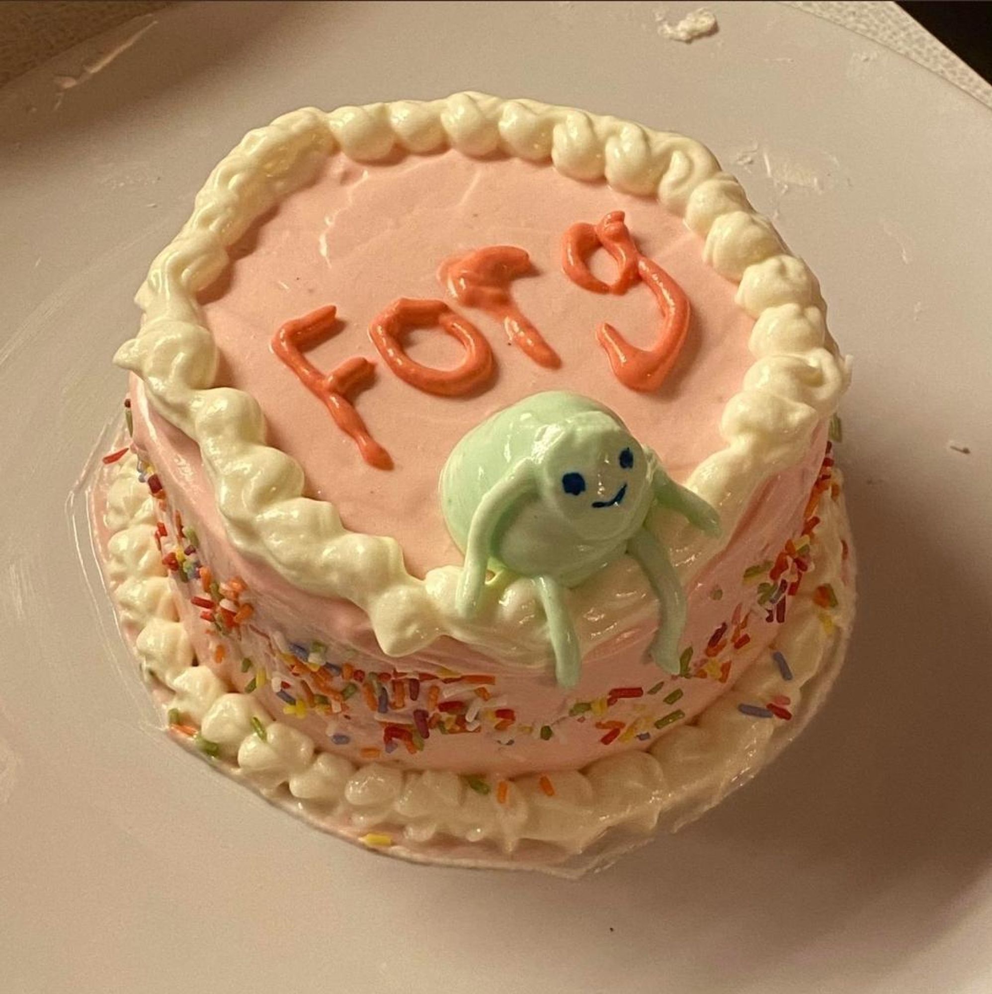 A cake with the word Forg on it. And something green which may be a forg.