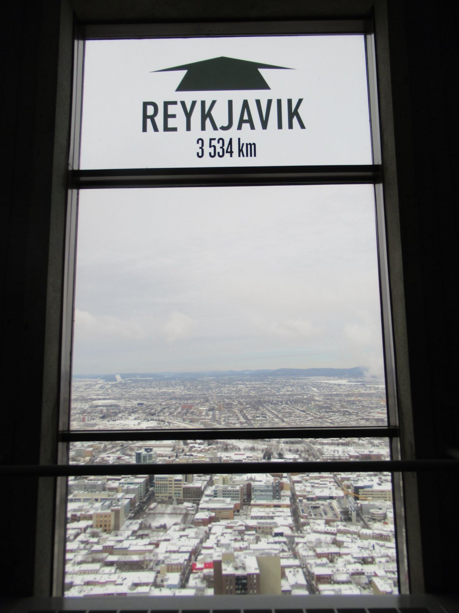 Fenêtre du complexe G à Québec, avec le nom de la ville de Reykjavik inscrit et le nombre de km (3534 km). (février 2019)