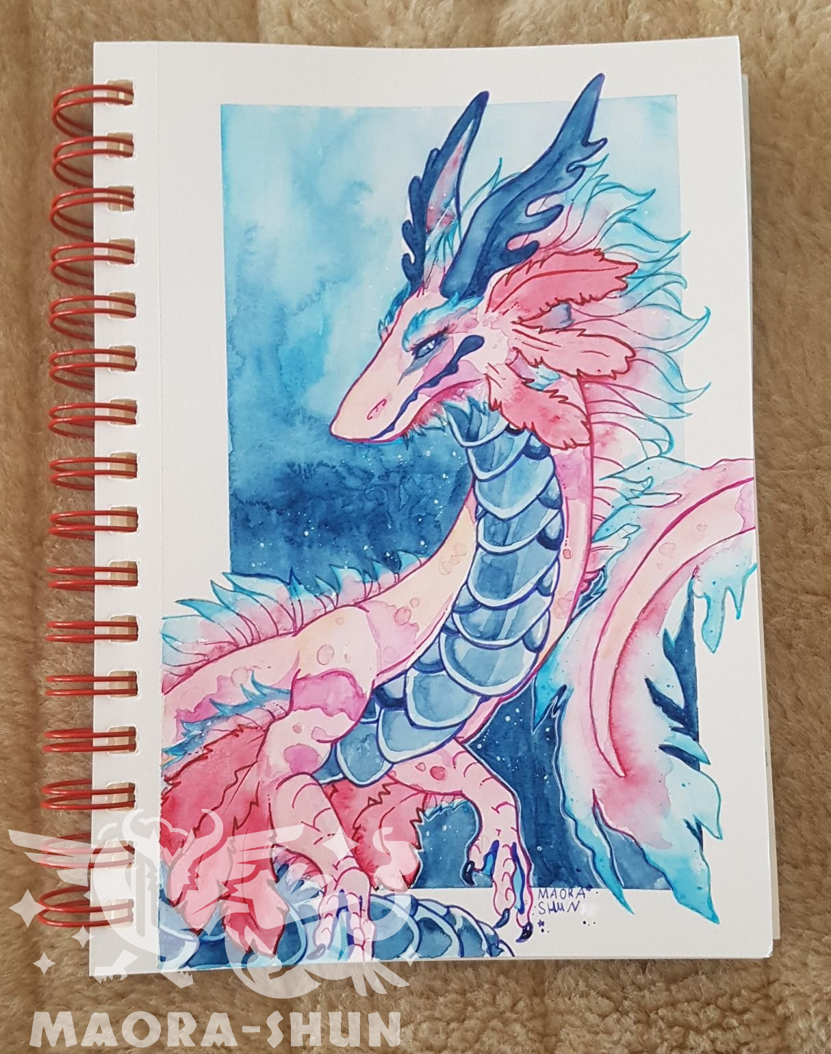 Pink Dragon on a blue background in a spiral scetchbook