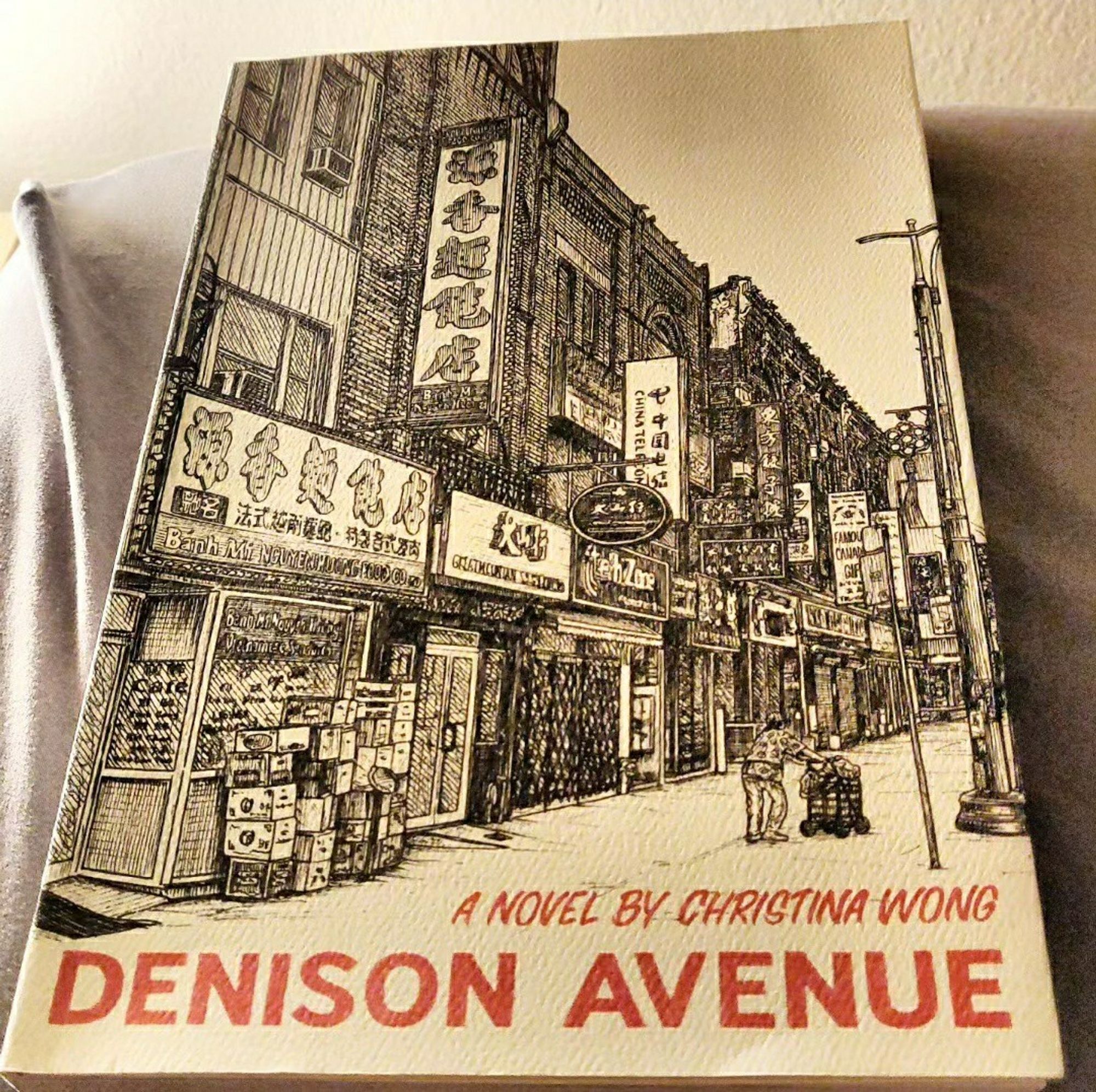 Picture of the book Denison Avenue by Christina Wong. Cover is a pencil sketch of a streetscape in Toronto's Chinatown.