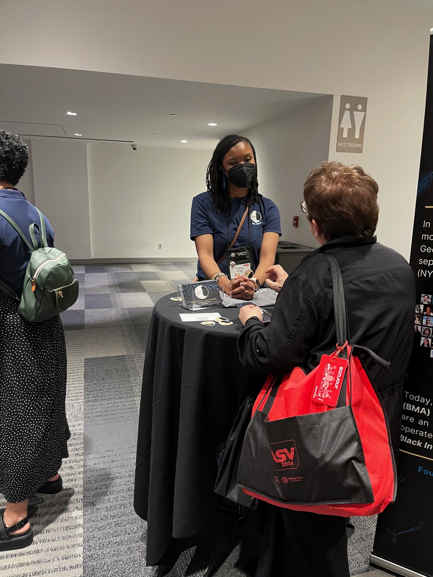 Conference attendees engaged in conversation at cocktail tables