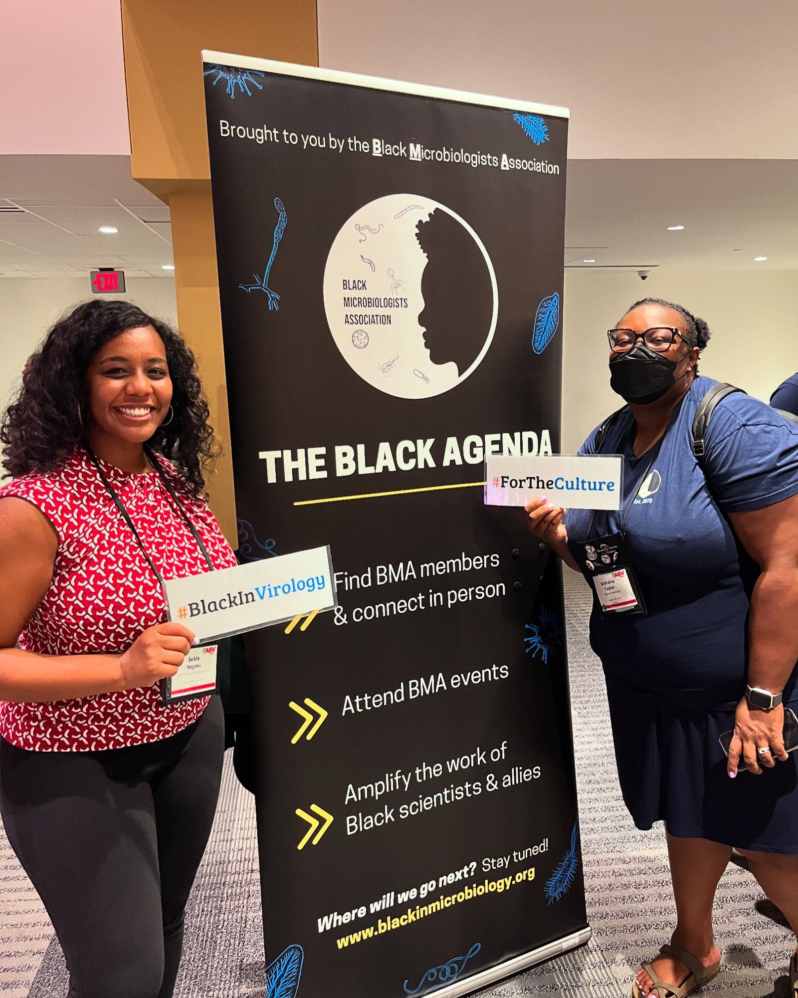 Conference attendees holding #BlackInVirology and #ForTheCulture signs