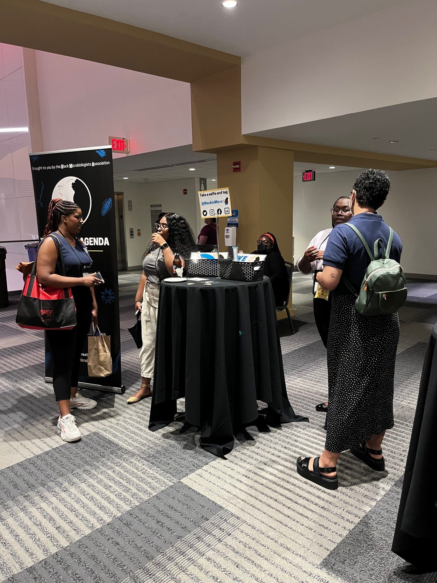 Conference attendees engaged in conversation at cocktail tables