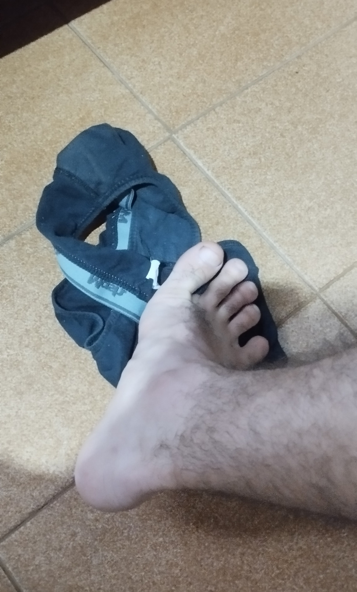 Um pé bem grande de 41 cm, aquela perna peluda bem bonita pisando em uma cueca preta suja de suor de pós academia