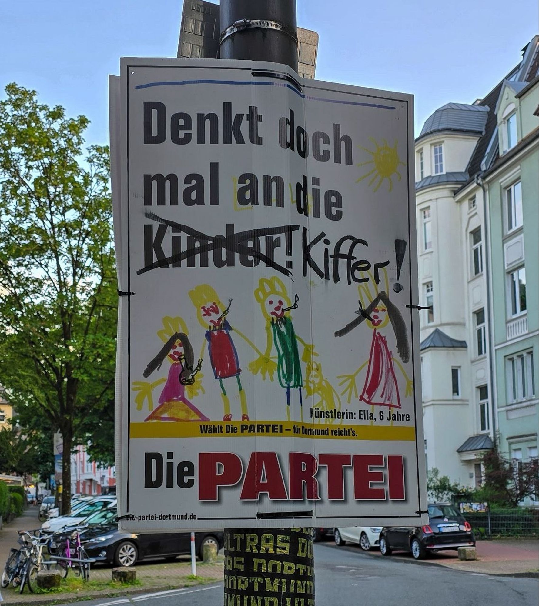 Ein Plakat der Partei Die PARTEI mit einer kindlichenZeichnung von vier Menschen. Darüber die Aufforderung „Denkt doch mal an die Kinder!“, wo bei das Wort „Kinder“ durchgestrichen und durch das Wort „Kiffer“ ersetzt wurde.