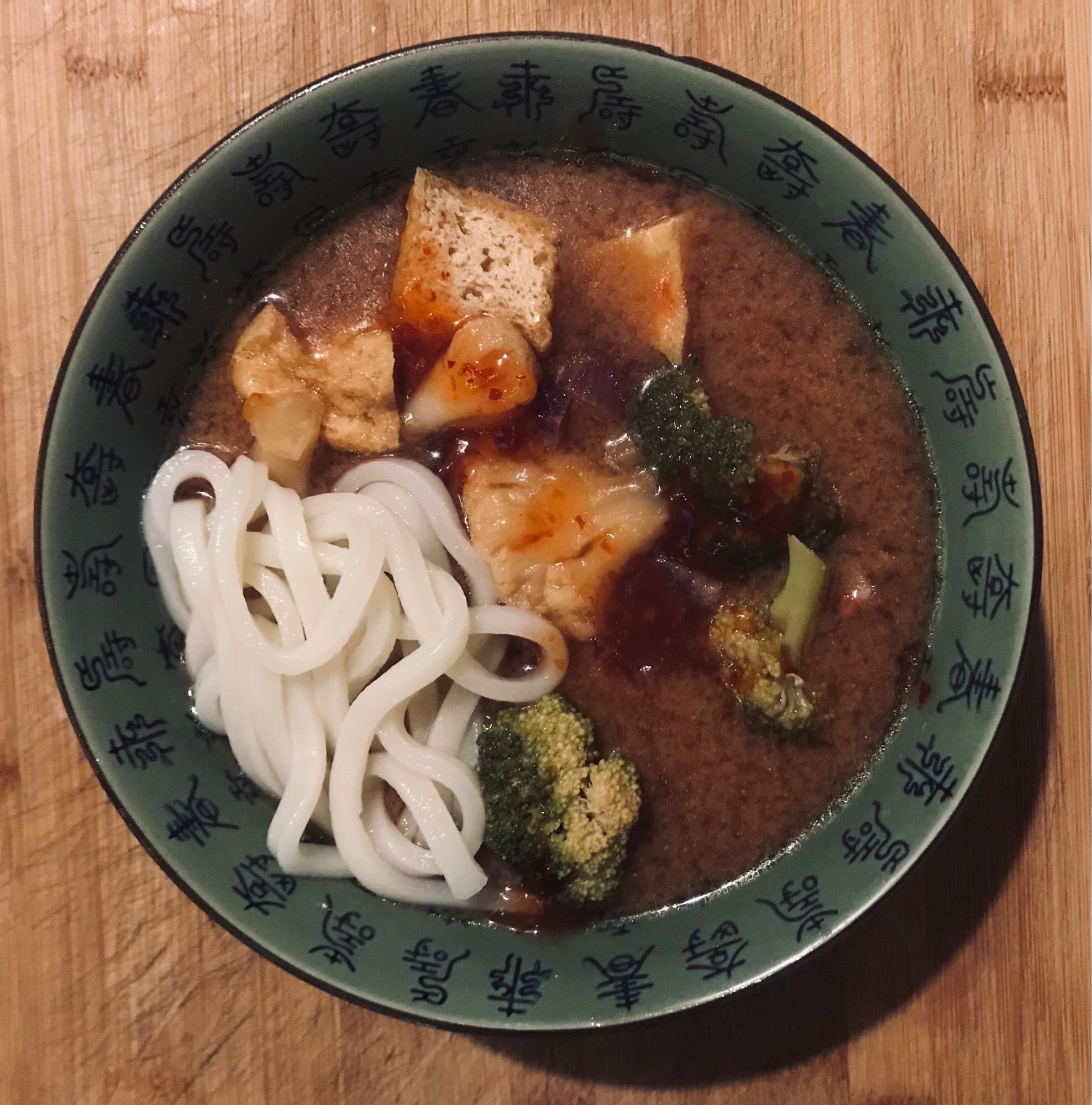 Grüne Schüssel, darin eine Asia Soup mit Gemüse, Tofu und Soba Nudeln