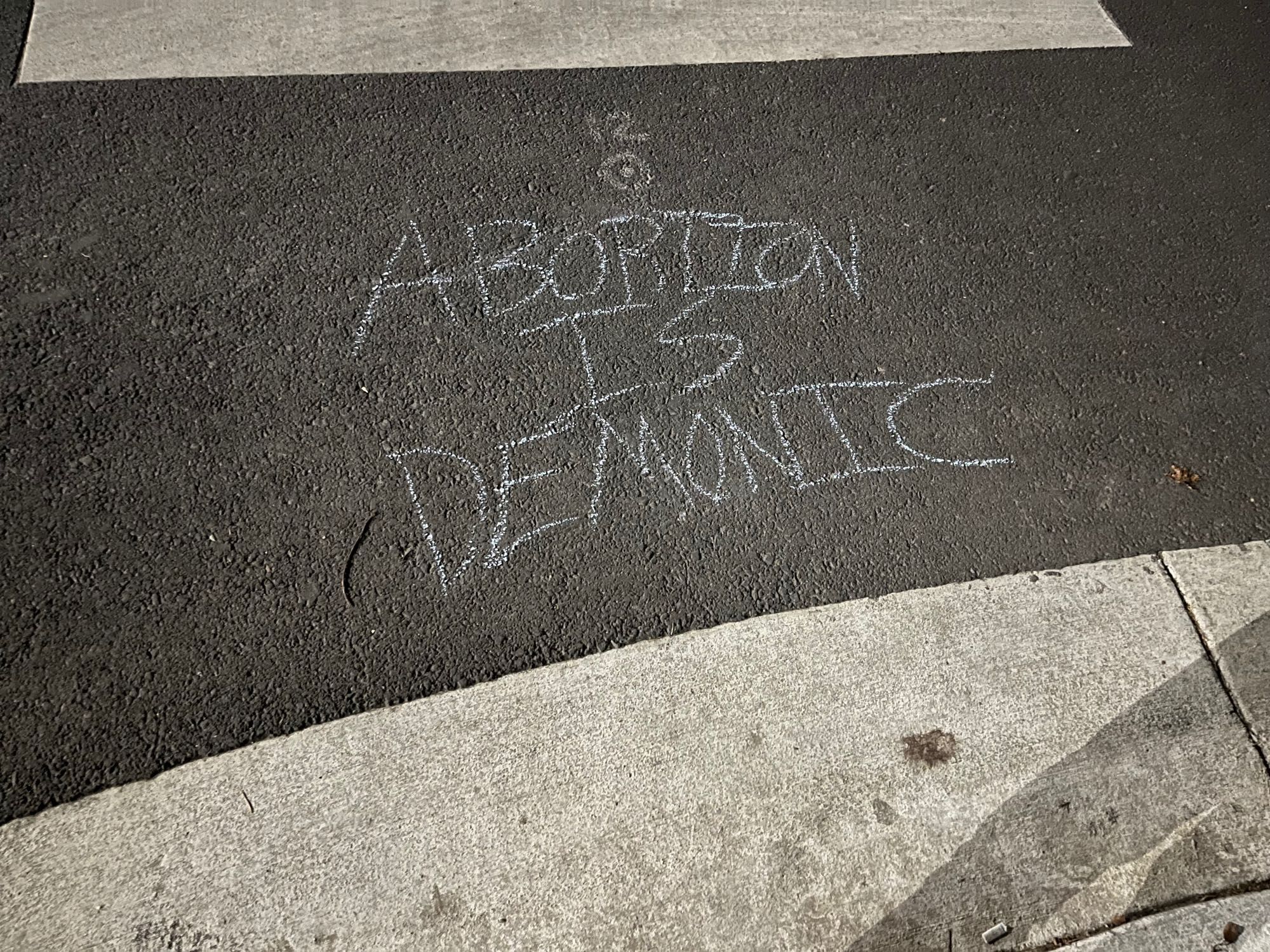 Chalk message on street reading “abortion is demonic”