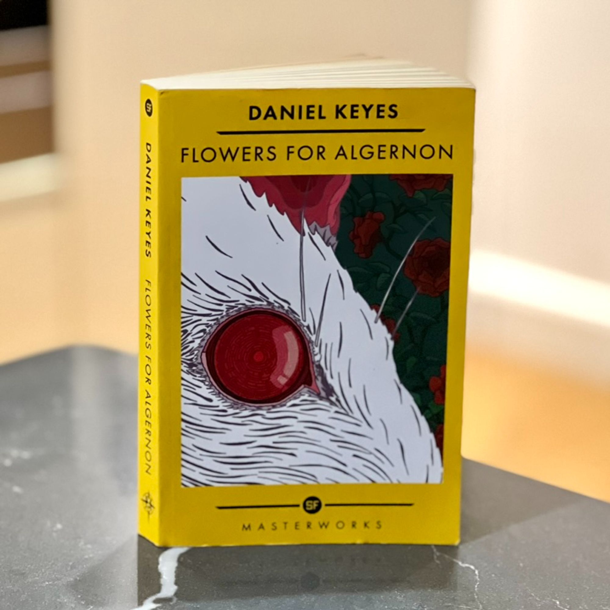 Photo of Flowers for Algernon by Daniel Keyes standing on a kitchen worktop. Cover is a close up of the red eye of a white mouse.