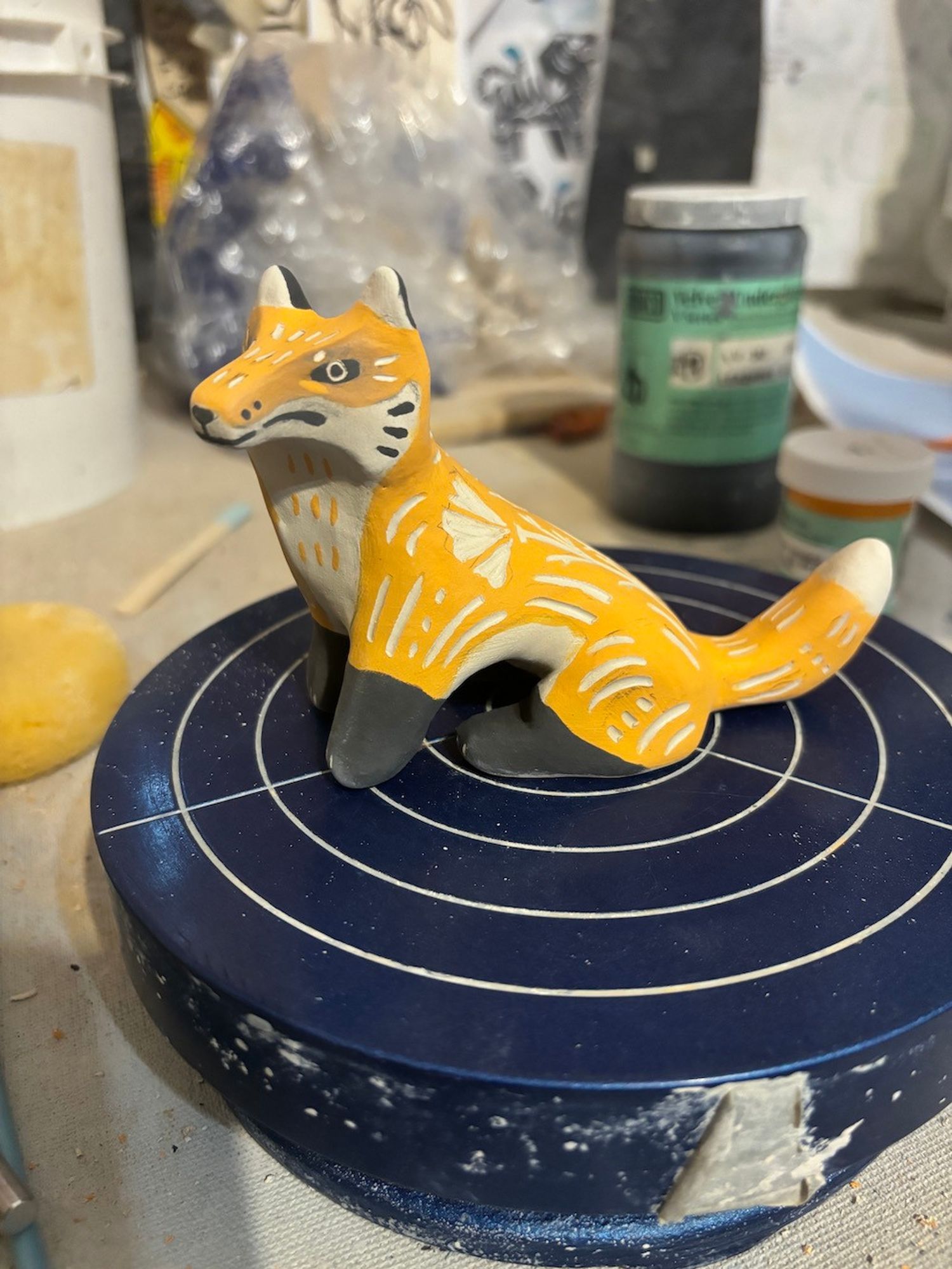 A greenware sgraffito fox animal sculpture. They are painted like that of a traditional fox, but they have a rather serious face vs the more gentle, serene look of my previous fox totem.