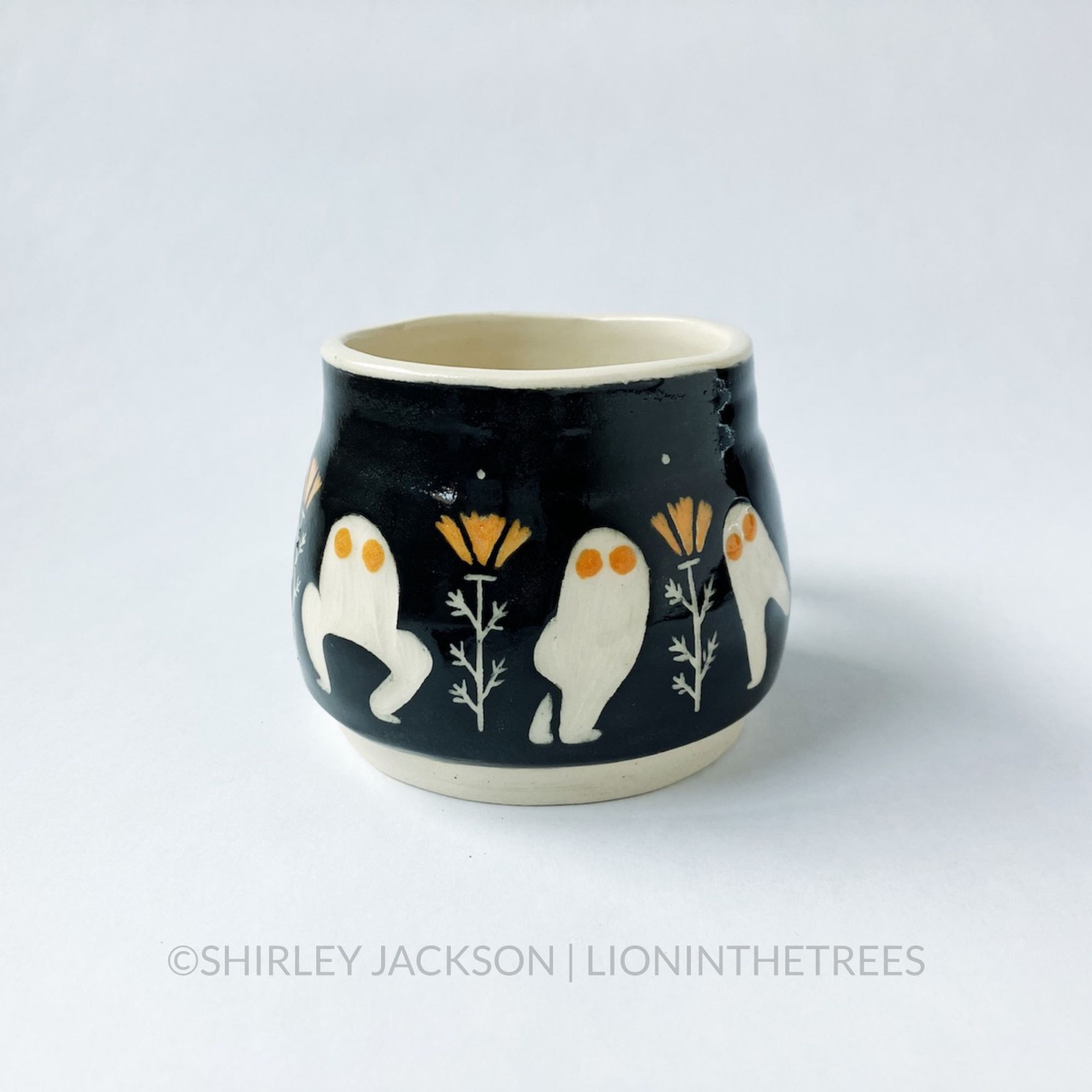 Ceramic black sgraffito mug with bright orange details featuring my Dance of the Fresno Nightcrawler motif and California Poppies.