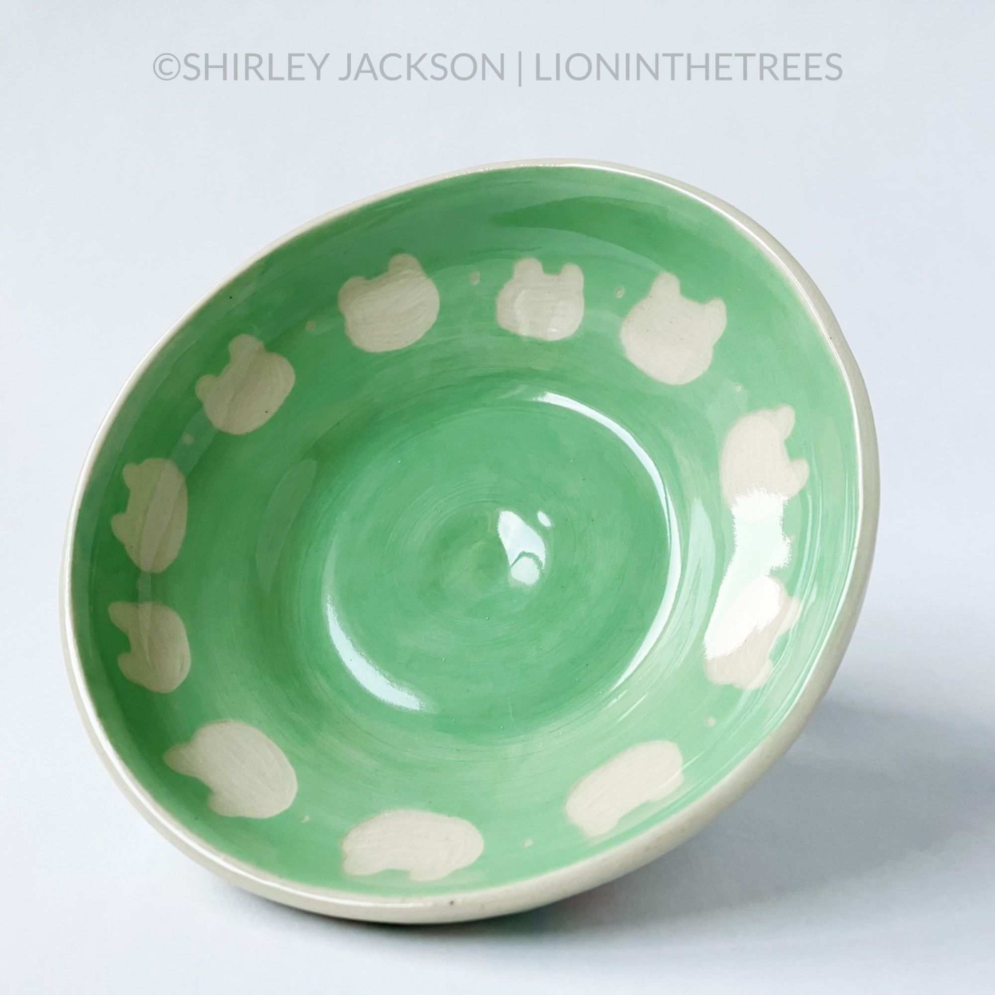 A photo showing the repeated silhouette frog face pattern that goes around the green interior of the dish