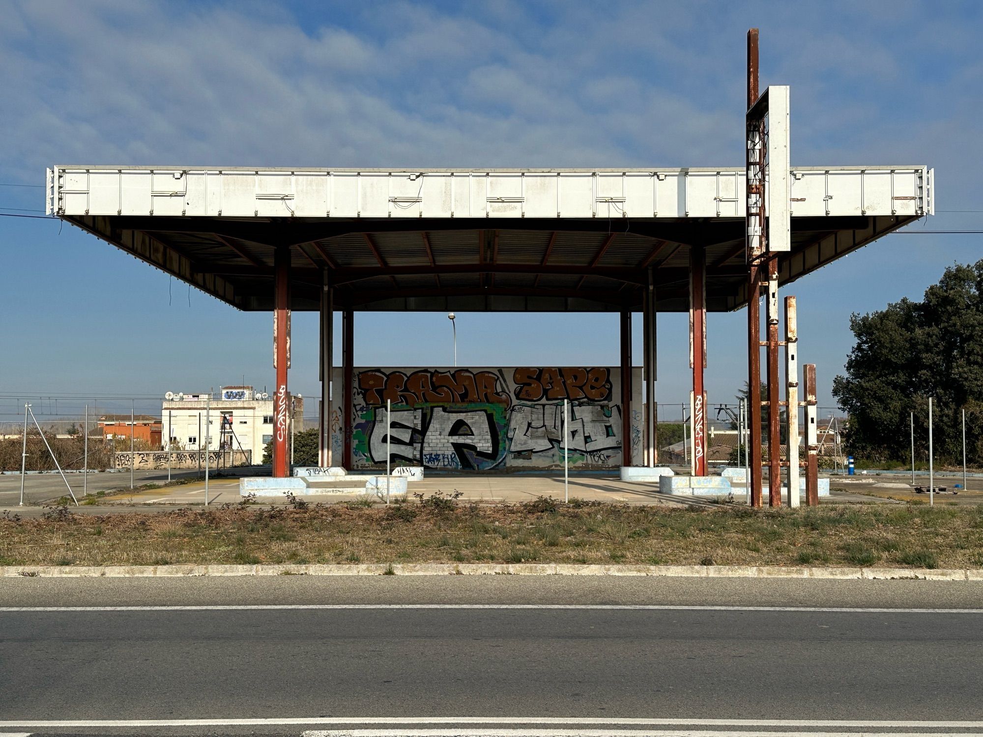 Tankstelle, geschlossen, zerstört an Landstraße mit blauem Himmel