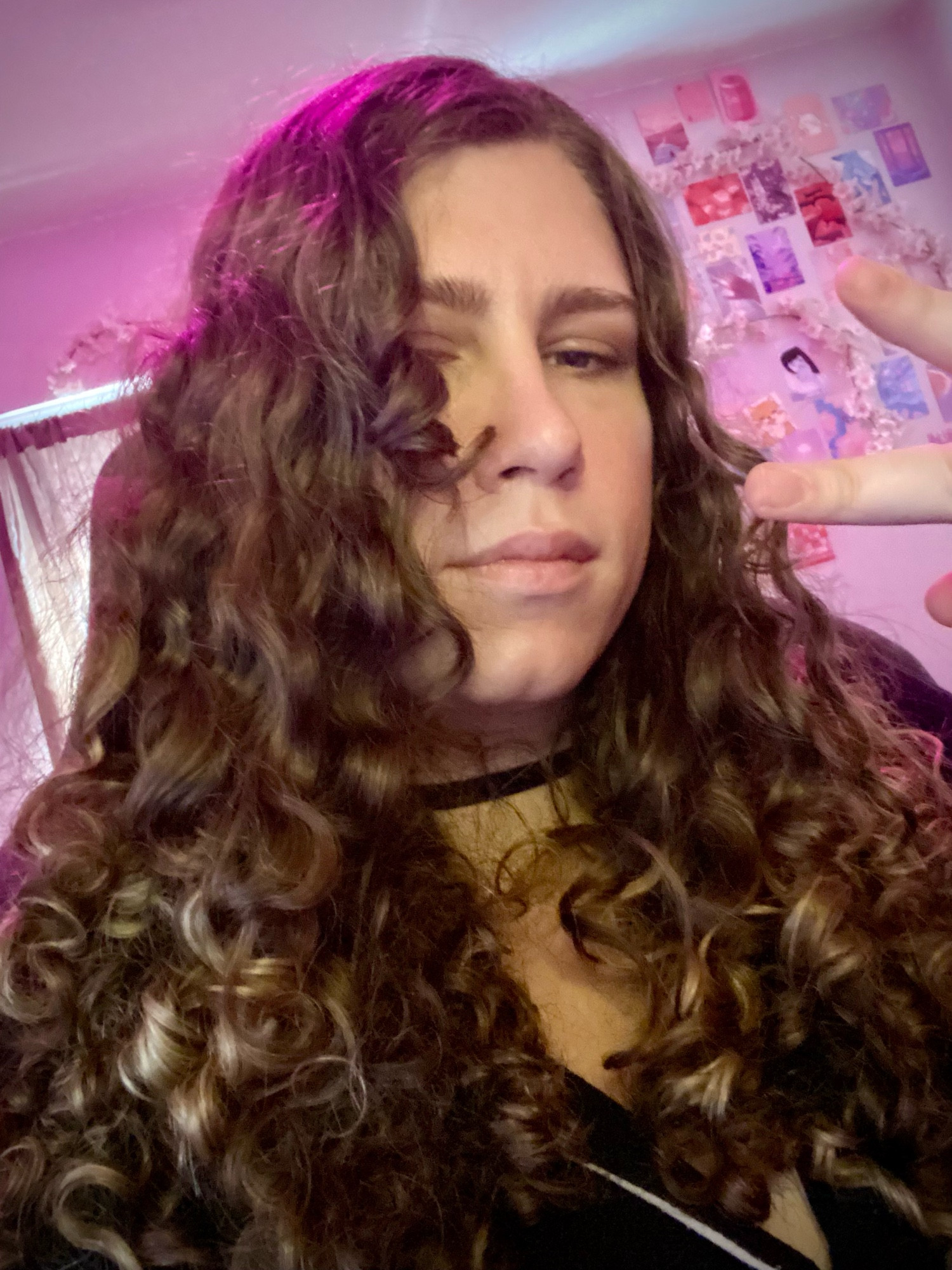 Melly chillin in pink lighting, picture is 95% curly hair