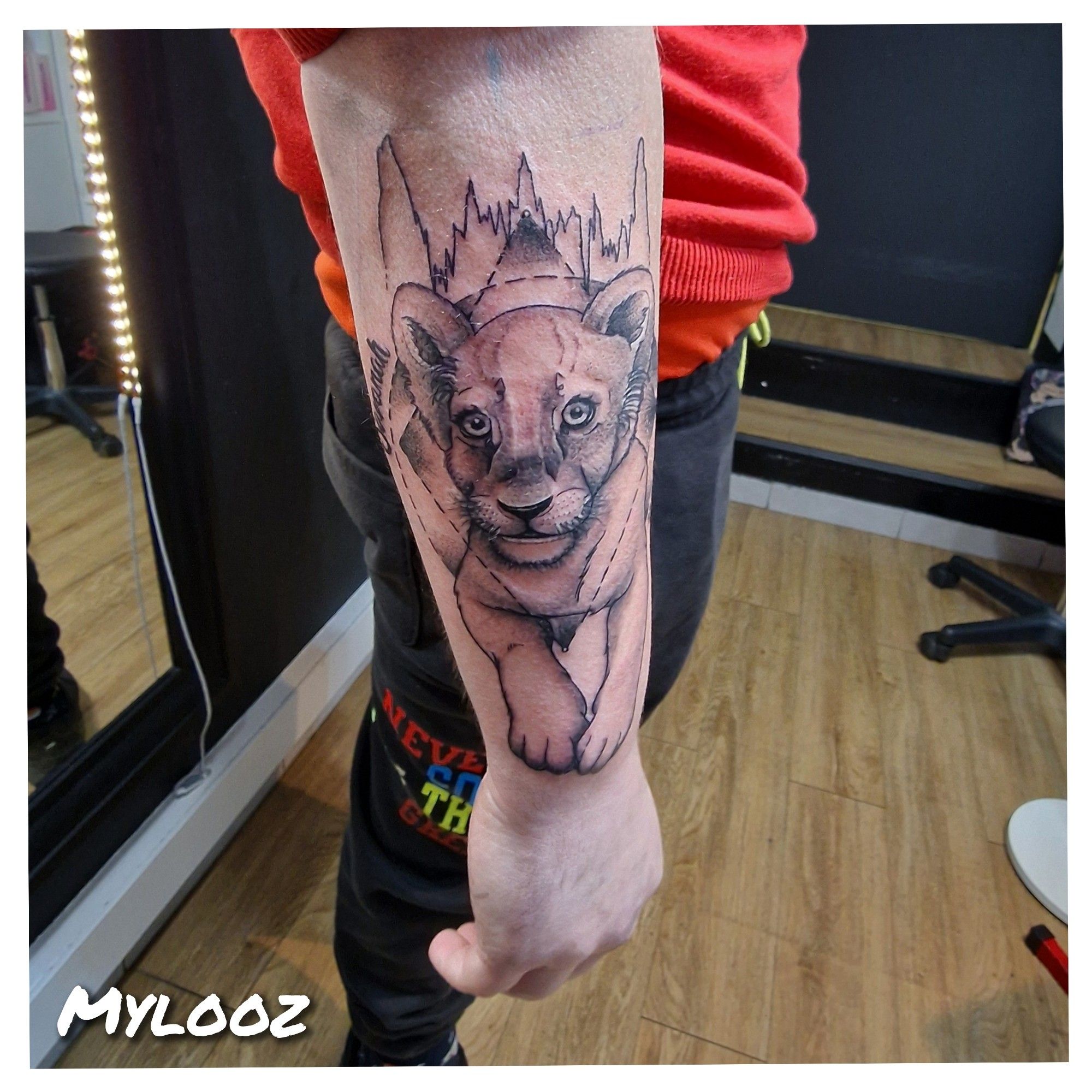 Photo d'avant bras tatoué. Le tattoo est un portrait de petite lionne en hommage à la fille du client.