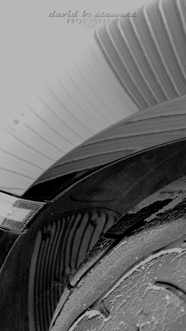 Title: Resting Motion

Lines with purpose... seldom noticed until we slow down. Our eyes may catch up, pay attention, realize, and take note.

View of light play and lines in the design of a front quarter panel, fender well vents, and tire of a Porsche Cayman 718 GT 4. 

#motorheadmonday #machinemonday
#monochromemonday #somelines #originalcontent #photographerlife #shareyourparadise #MagnificentMonochrome #samsung #S23Ultra