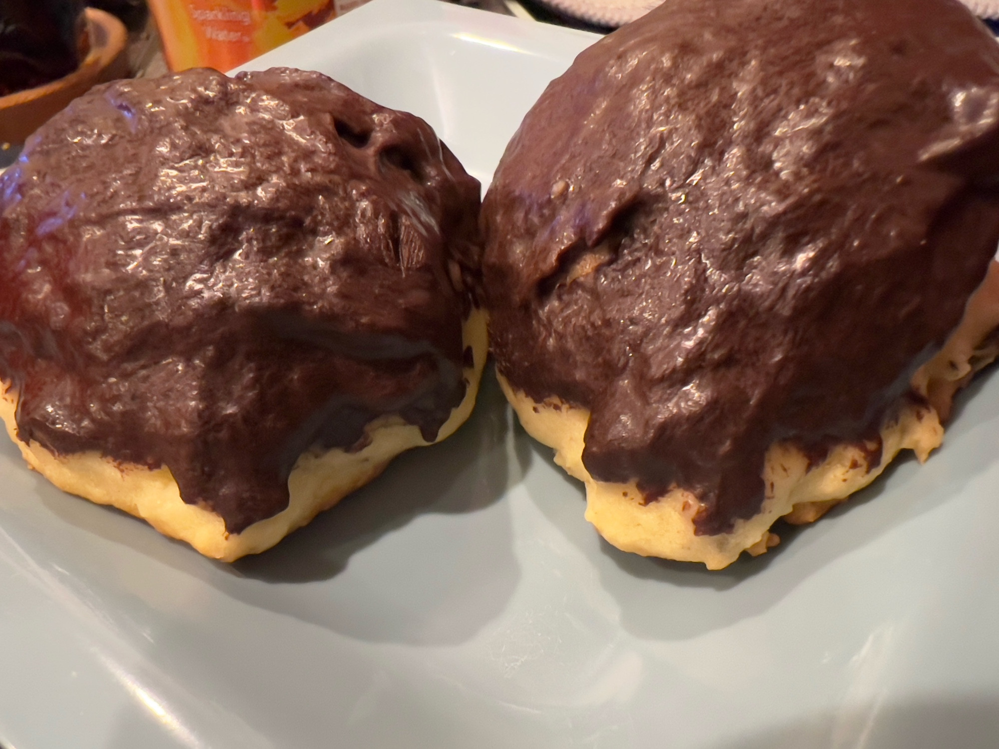 Two lump-ish, cake-y cookies coated in dark chocolate, sitting on a pale blue plate.